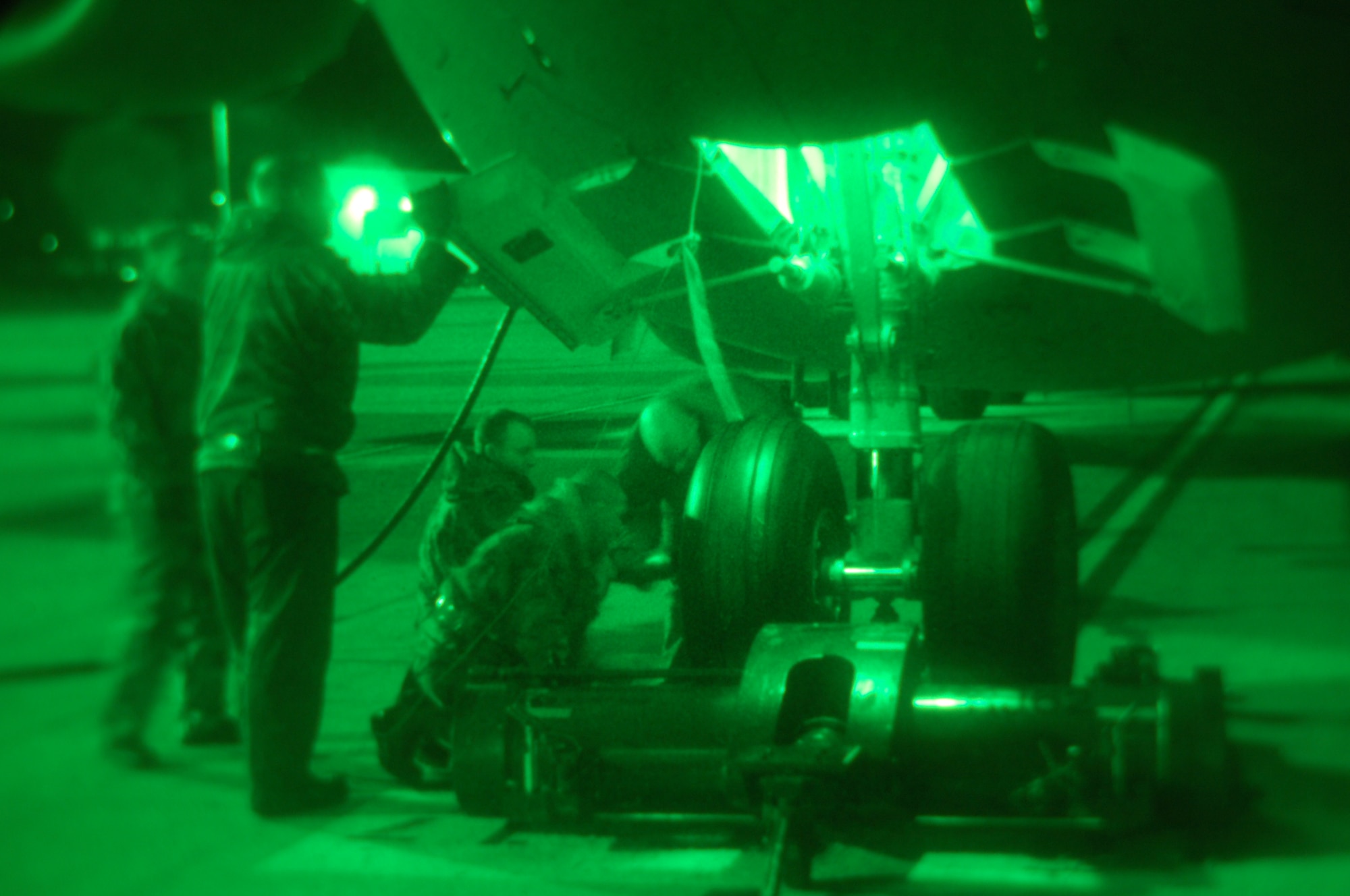 Staff Sgt. Ray Northcutt, 723rd Air Mobility Squadron, (far right) and other 723rd AMS members inspect the front left tire of a C-17 Globemaster III during its pit stop at Ramstein Dec. 13. The C-17 was then loaded with cargo and launched to its next destination. (U.S. Air Force photo/Airman 1st Class Kenny Holston)