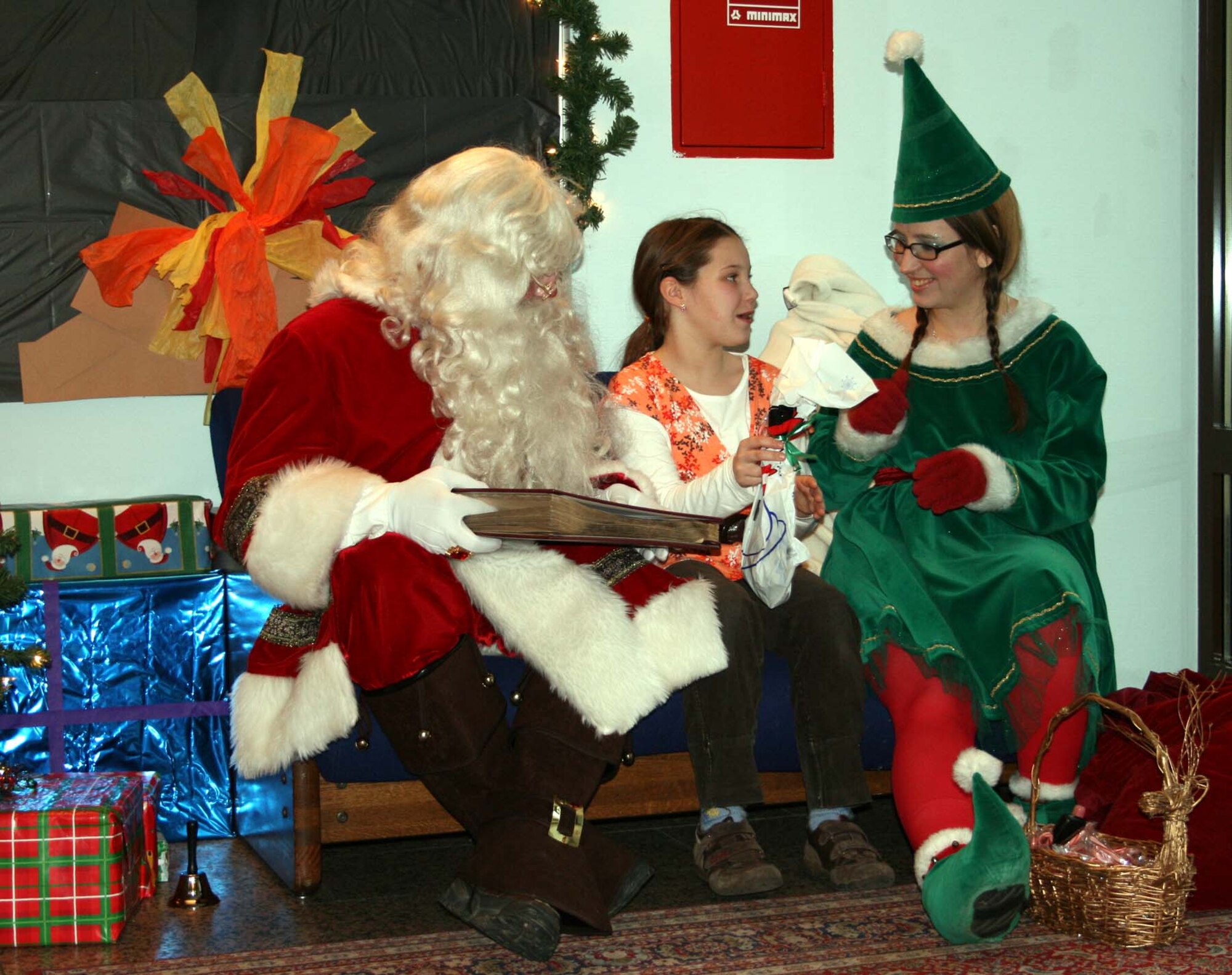 SPANGDAHLEM AIR BASE, Germany -- Sabine Toller receives a gift from Santa Claus’ head elf Jenifer Calhoun at the Spangdahlem Youth Center’s Children’s Christmas Party Dec. 15, 2007. According to Santa Claus this year’s hot items are video game systems, dolls, fire trucks, dogs and ponies. (Photo by Biggi Piper)