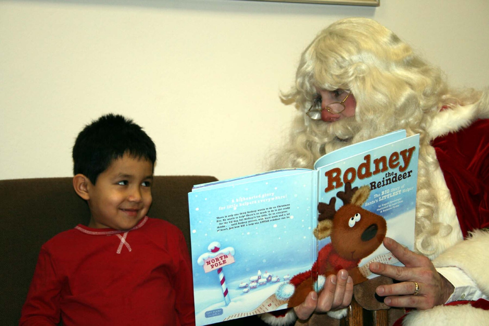 SPANGDAHLEM AIR BASE, Germany -- Matthew Gil, son of Master Sgt. Sergio Gil, 52nd Civil Engineering Squadron Fire Protection Flight and Griselda Gil 52nd Aircraft Maintenance Squadron, listens as Santa Claus reads Rodney the Reindeer: Santa’s Littlest Helper. Santa Claus and head elf Jenifer Calhoun stopped by the Bitburg Libary to enjoy milk and cookies and meet with children Dec. 14, 2007. (Photo by Biggi Piper)