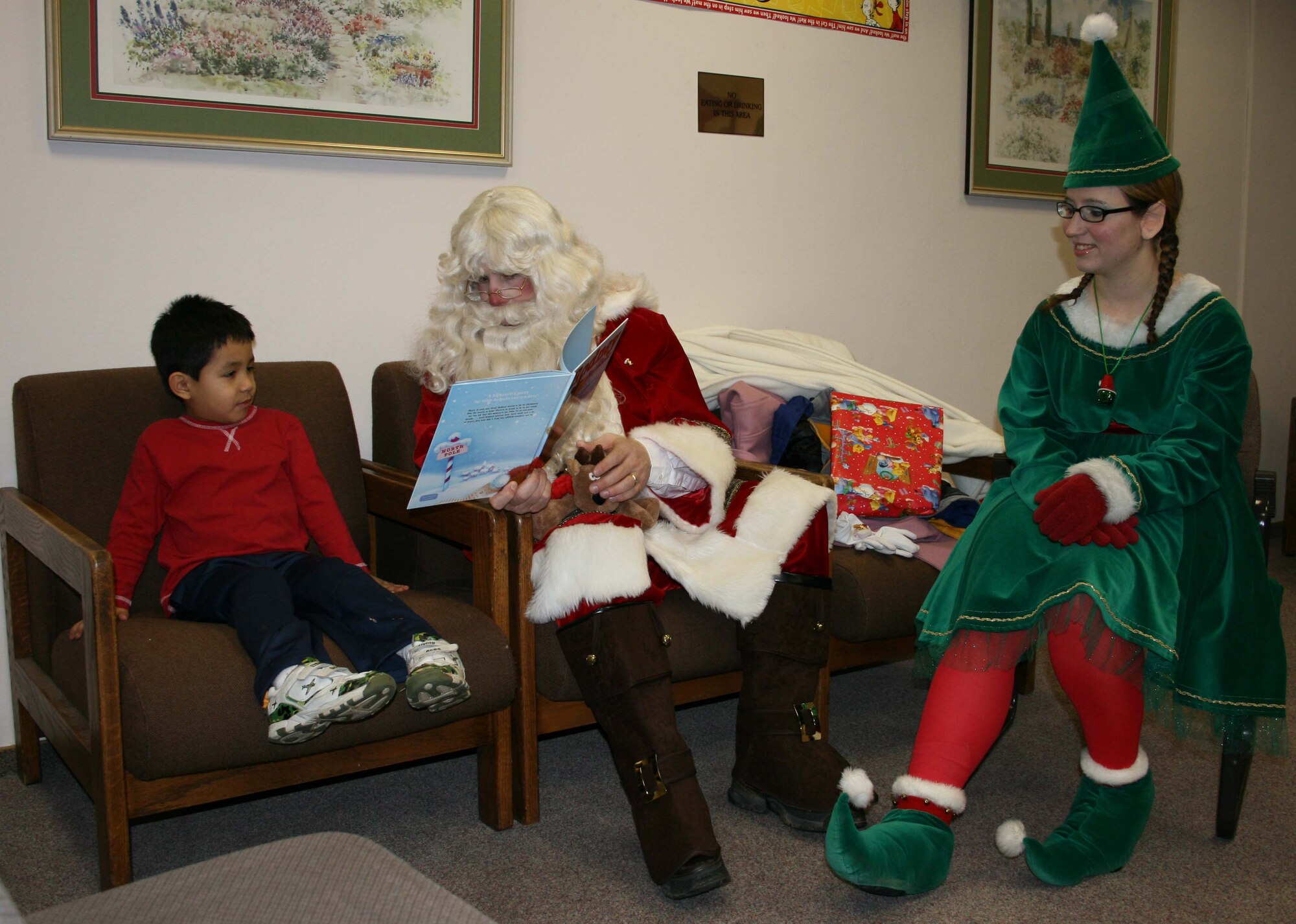 SPANGDAHLEM AIR BASE, Germany -- Matthew Gil, son of Master Sgt. Sergio Gil, 52nd Civil Engineering Squadron Fire Protection Flight and Griselda Gil 52nd Aircraft Maintenance Squadron, listens as Santa Claus read a book Dec. 14, 2007. Santa Claus and head elf Jenifer Calhoun visited the Bitburg Library to read children’s stories and find out what they want for Christmas. Matthew told Santa Claus he wants a fire truck for Christmas. (Photo by Biggi Piper)