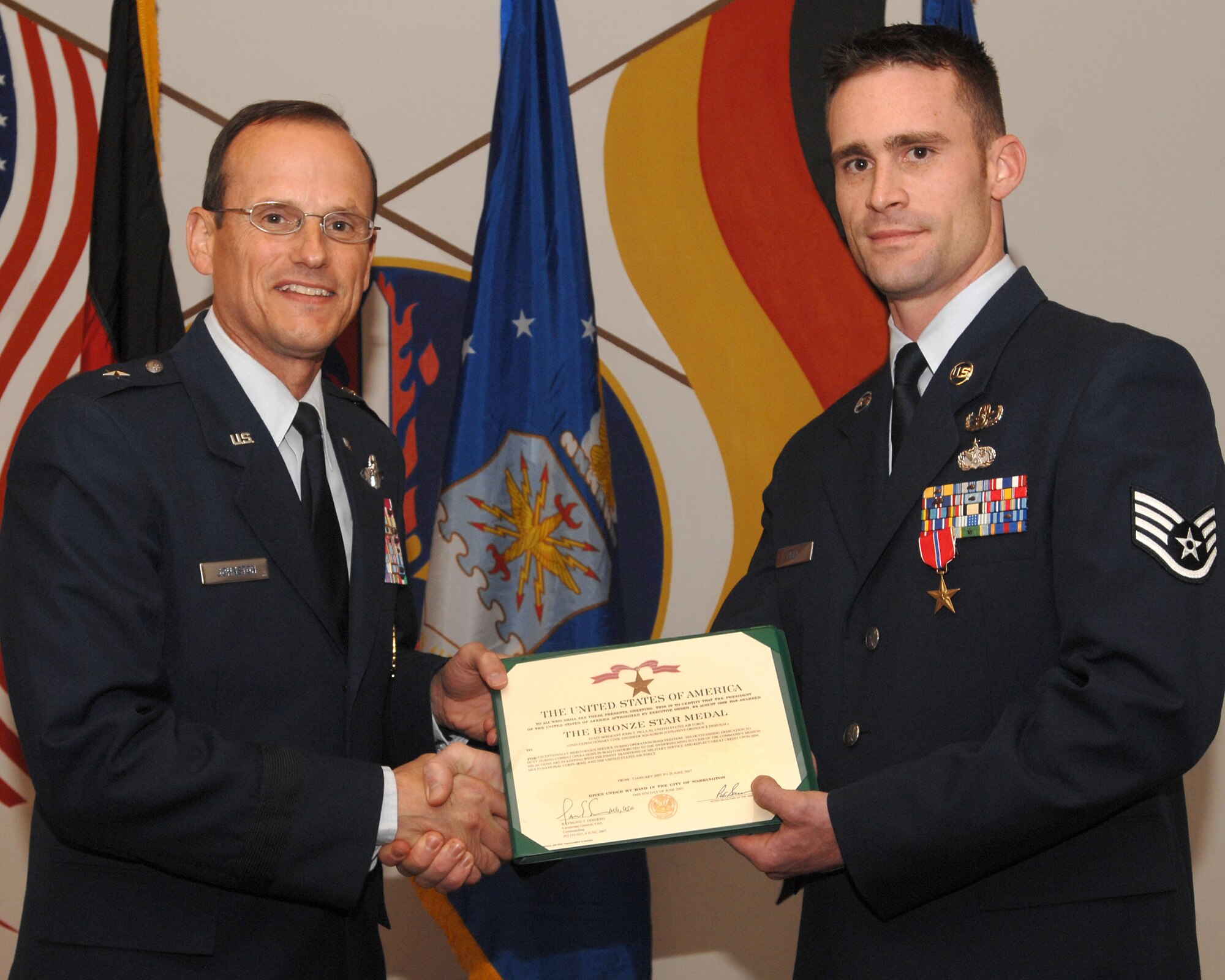 Brigadier Gen. Rich Johnston, 86th Airlift Wing commander, congratulates Staff Sgt. Tom Pilla, 86th Construction and Training Squadron Explosive Ordnance Disposal instructor, during his Bronze Star award ceremony Dec. 13 at Ramstein Air Base, Germany. Sergeant Pilla was awarded the Bronze Star medal for meritorious conduct during operations in Iraq.  (U.S. Air Force photo/Airman 1st Class Kenny Holston)