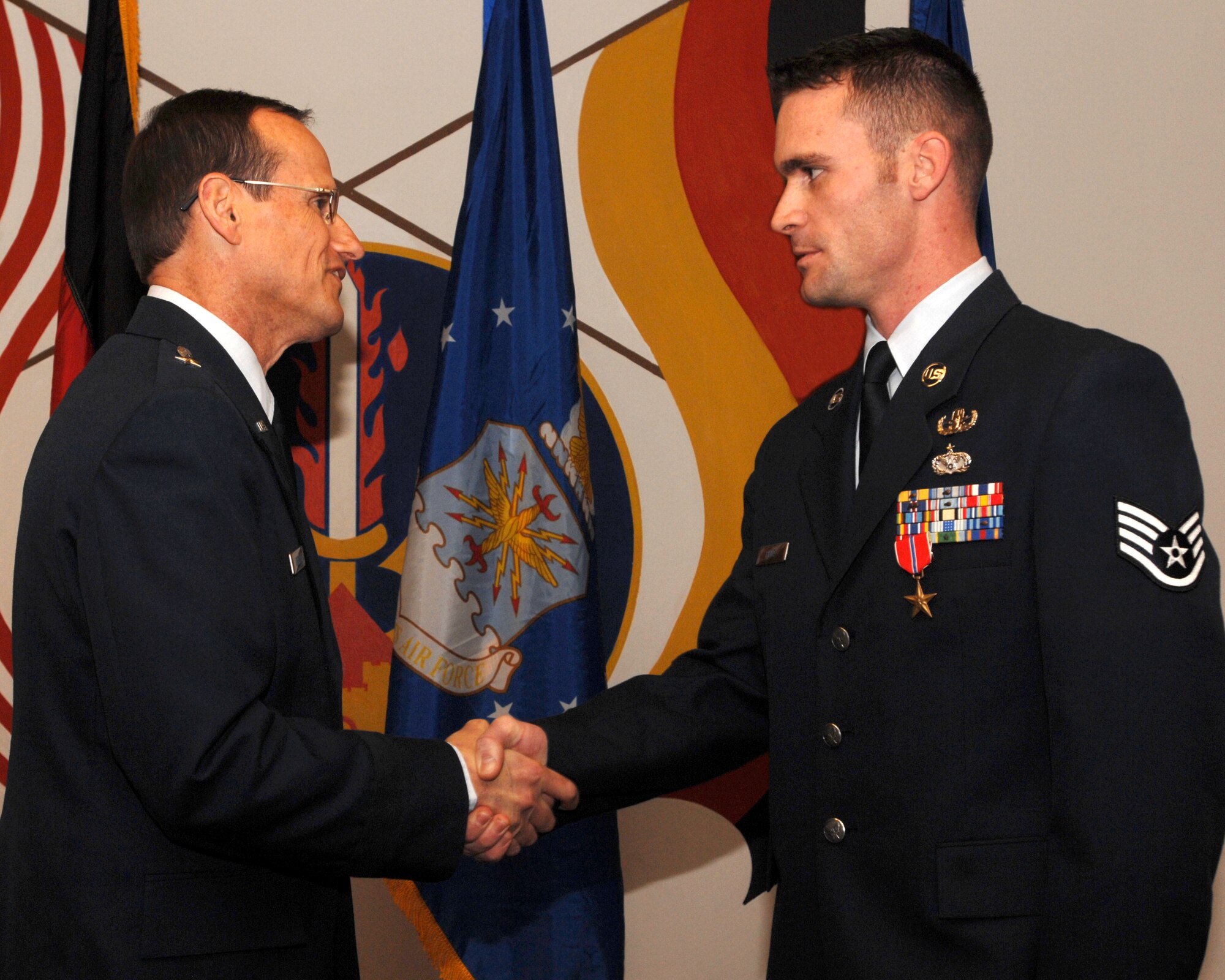 Brigadier Gen. Rich Johnston, 86th Airlift Wing commander, congratulates Staff Sgt. Tom Pilla, 86th Construction and Training Squadron Explosive Ordnance Disposal instructor, during his Bronze Star award ceremony Dec. 13 at Ramstein Air Base, Germany. Sergeant Pilla was awarded the Bronze Star medal for meritorious conduct during operations in Iraq.  (U.S. Air Force photo/Airman 1st Class Kenny Holston)