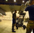 KUNSAN AIR BASE, South Korea -- Staff Sgt. Danny Colon (left), 8th Aircraft Maintenance Squadron, spots his teammates as they load a bomb during the weapons load competition here Dec. 14.  This was the final weapons load competition between the 80th and 35th Fighter Squadrons for 2007.  (U.S. Air Force photo/Senior Airman Steven R. Doty)