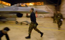 KUNSAN AIR BASE, South Korea -- Senior Airman Jon Michael Schwartz, 8th Aircraft Maintenance Squadron, runs to retrieves tools during the weapons load competition here Dec. 14.  This was the final weapons load competition between the 80th and 35th Fighter Squadrons for 2007.  (U.S. Air Force photo/Senior Airman Steven R. Doty)