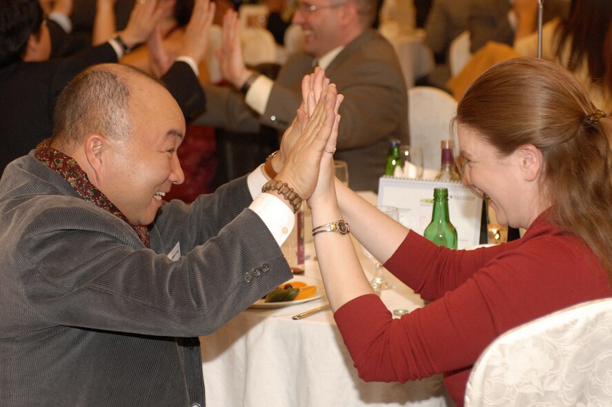 GUNSAN CITY, South Korea -- Mr. So, Dong Sup and Lieutenant Dallas Webb, Chief Community Support Flight from 8th Services Squadron, high five each other during a dinner Dec. 13 here. The Annual Friendship Dinner is part of the Good Neighbor Program that highlights the relationship between the Republic of Korea and United States' military. (U.S. Air Force photo/Senior Airman Giang Nguyen)

