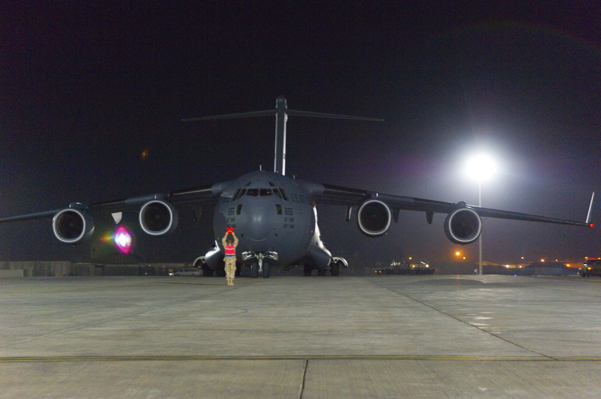 BALAD AIR BASE, Iraq -- A crew chief marshals in a C-17 Globemaster III for download on the flightline here Dec. 8. The C-17 was here delivering three new Mine Resistant Ambush Protected vehicles for the Army. (U.S. Air Force photo/Staff Sgt. Travis Edwards)