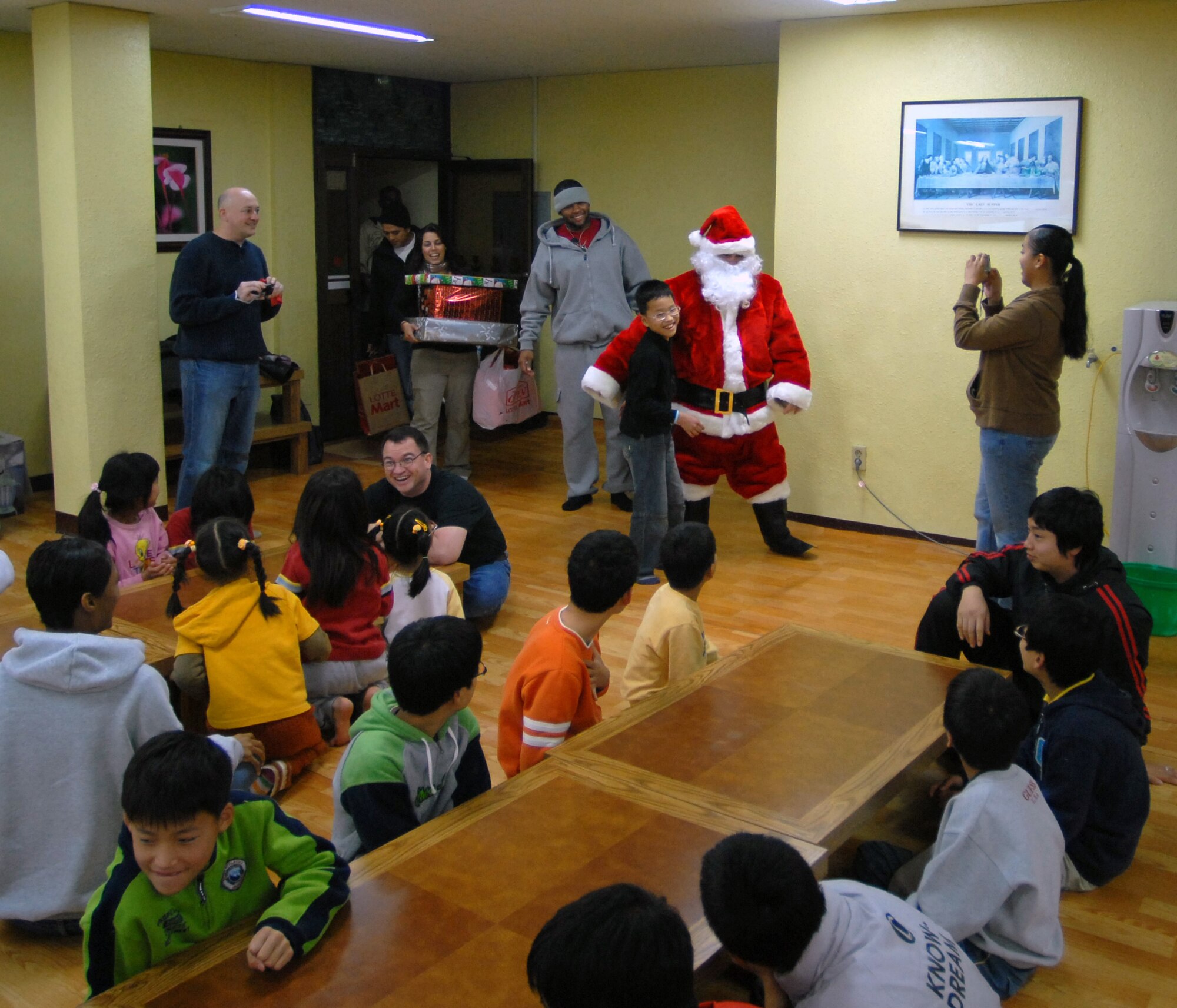 KAE JONG, South Korea -- Technical Sgt. John Craven, Santa, makes a surprise visit to Kae Jong orphanage to hand out gifts here Dec. 15.  Airmen from Kunsan Air Base spent the afternoon handing out gifts, coloring, eating, and playing with children during an Airmen Committed to Excellence (A.C.E.) sponsored trip.  8th Fighter Wing Airmen donated various gifts to include beanie babies by 8th Communications Squadron and a Play Station 2 by A.C.E.  (U.S. Air Force photo/Senior Airman Steven R. Doty)