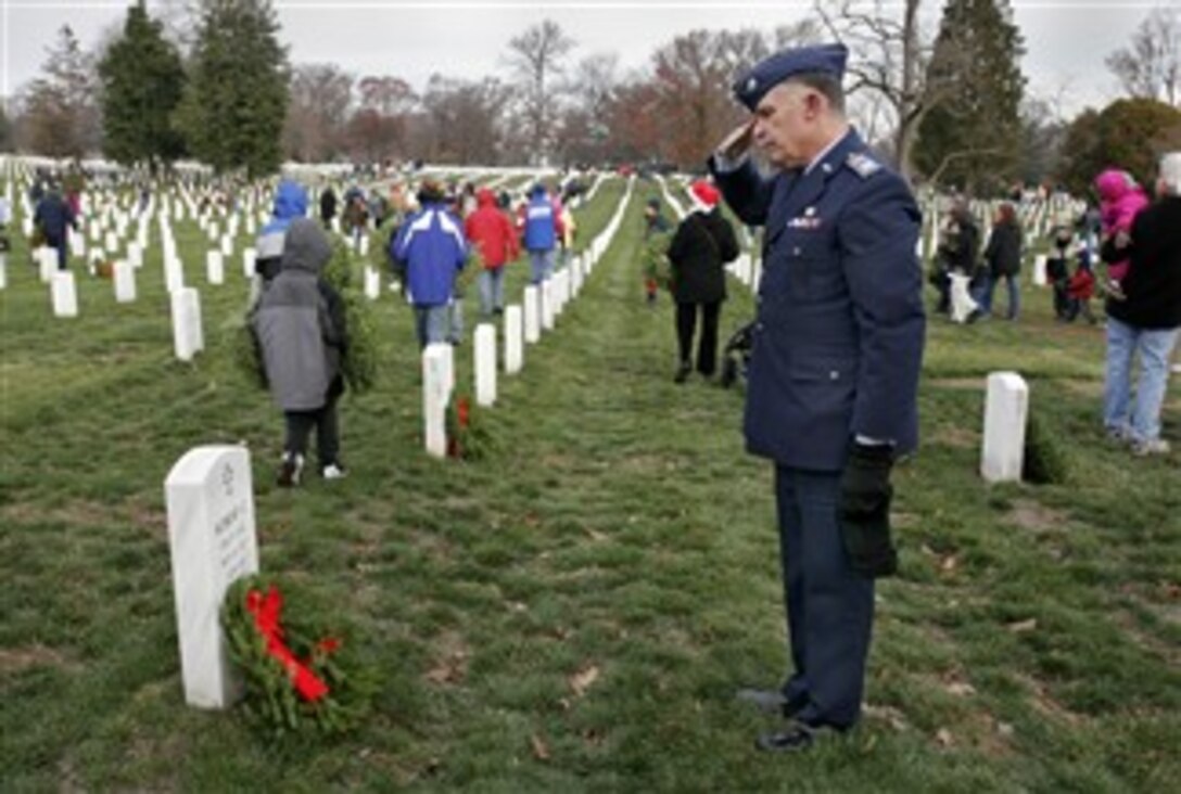 Charles "Chuck" Wright, commander of the Kansas City Composite Squadron, a civil air patrol, salutes after he places a wreath on the son of a veteran, Dec. 15, 2007, at Arlington National Cemetery. Wright, a Vietnam War Marine veteran, volunteered to place some of the 10,000 wreaths donated by the Worcester Wreath Company of Harrington, Maine.