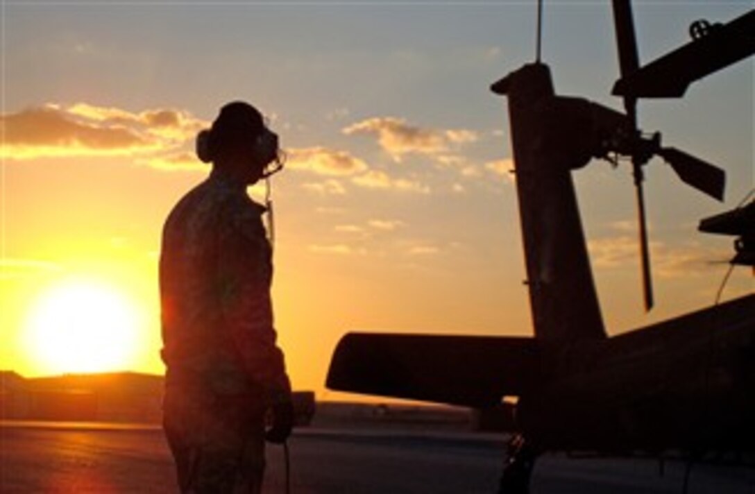 An AH-64 Apache Longbow crew chief prepares a 1st Attack Reconnaissance Battalion, 1st Aviation Regiment, gunship for a night mission, Dec. 16, 2007. 
