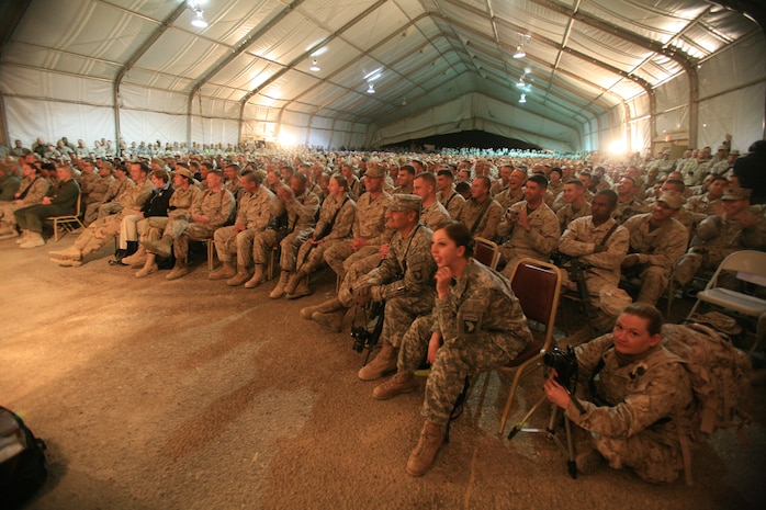 AL TAQADDUM, Iraq (Dec. 18, 2007) ? Servicemembers look on as comedian Lewis Black performs on stage as part of a United Service Organization tour here Dec. 18.  Black, along with Robin Williams, Miss USA Rachel Smith, Kid Rock and Lance Armstrong, came to visit troops during the holiday season.  The celebrities will continue their tour throughout the season making additional stops in Iraq and Afghanistan.