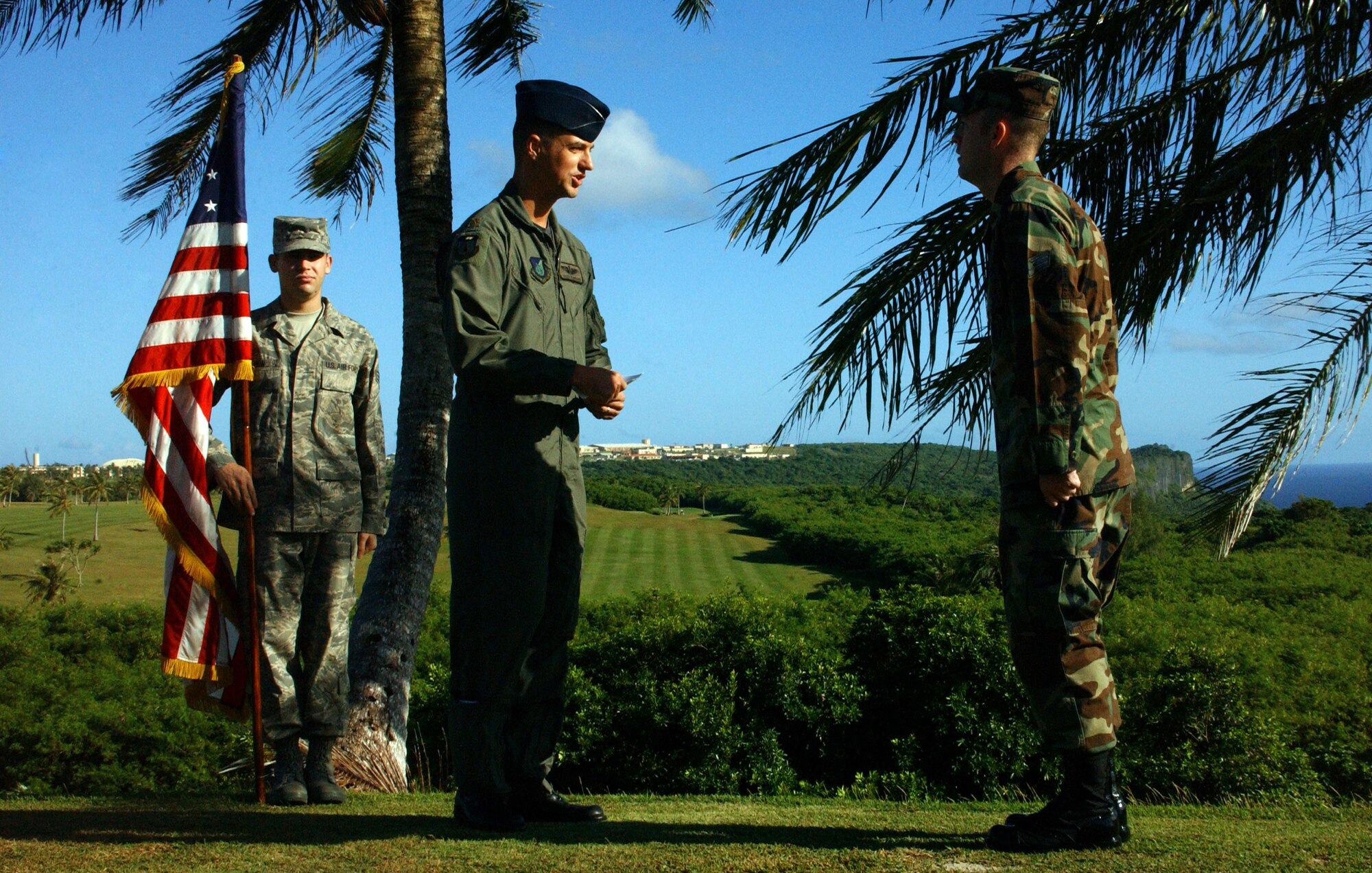 Maj. Alex Jernigan, 393rd EBS mission planning cell team chief, re-enlists Senior Airman Tyler Cresap here December 14 prior to the Team Andersen Challenge. Airman Cresap’s re-enlistment took place on a hill above Andersen’s scenic golf course, where he and his teammate, Senior Airman Todd Anderson, eventually won the large unit golf tournament. (Air Force photo/Tech. Sgt. Steven Wilson) 