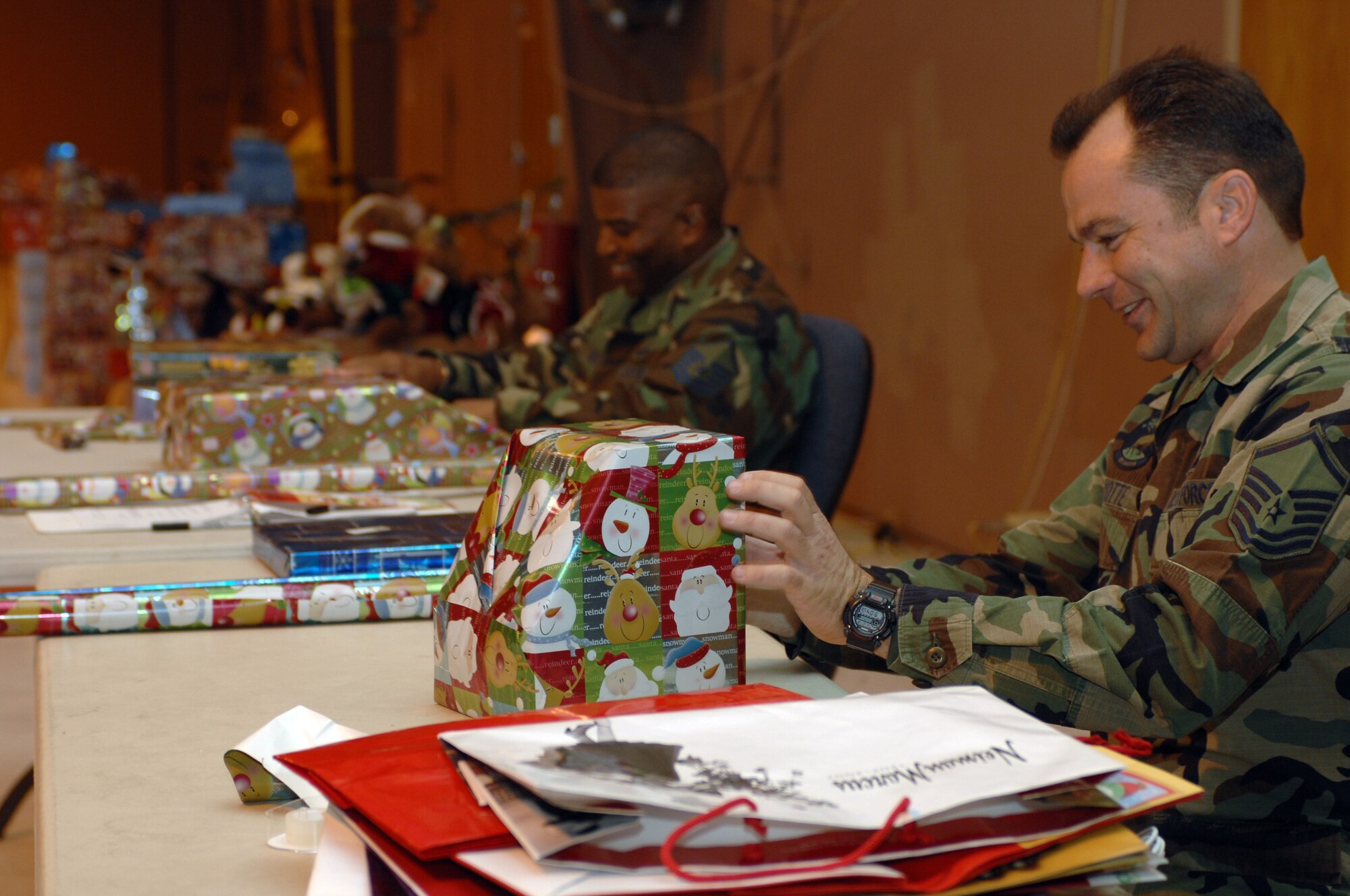 Volunteers Master Sgts. Garrett Ayotte, 57th Aircraft Maintenance Squadron (foreground), and Curtis Green, 53rd Test and Evaluation Group, carefully wrap donated toys as part of Nellis’ Adopt-A-Family program, Dec. 18. The Nellis AFB First Sergeants Association sponsored the Adopt-A-Family program which benefited more than 300 military families. More than 3,500 gifts were donated by Nellis personnel, local businesses and community members. Gifts were delivered to the families on Dec. 20 and 21. (U.S. Air Force photo by Senior Airman Nadine Y. Barclay)