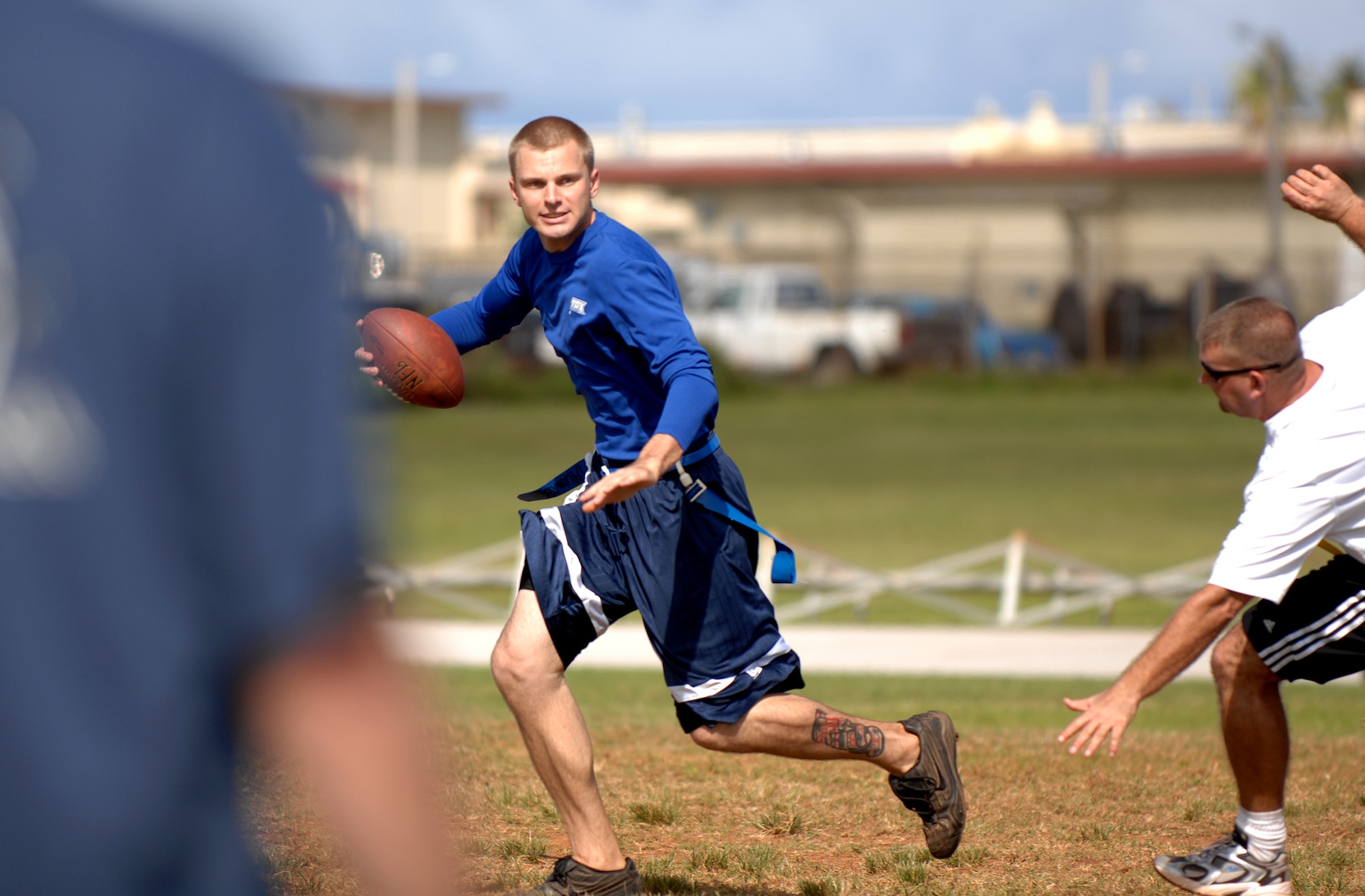 A member of the 36th Services Squadron evades a defender while looking down field to make a pass during a football match held during the Team Andersen Challenge, Dec. 14. (U.S. Air Force photo/Senior Airman Miranda Moorer)                  