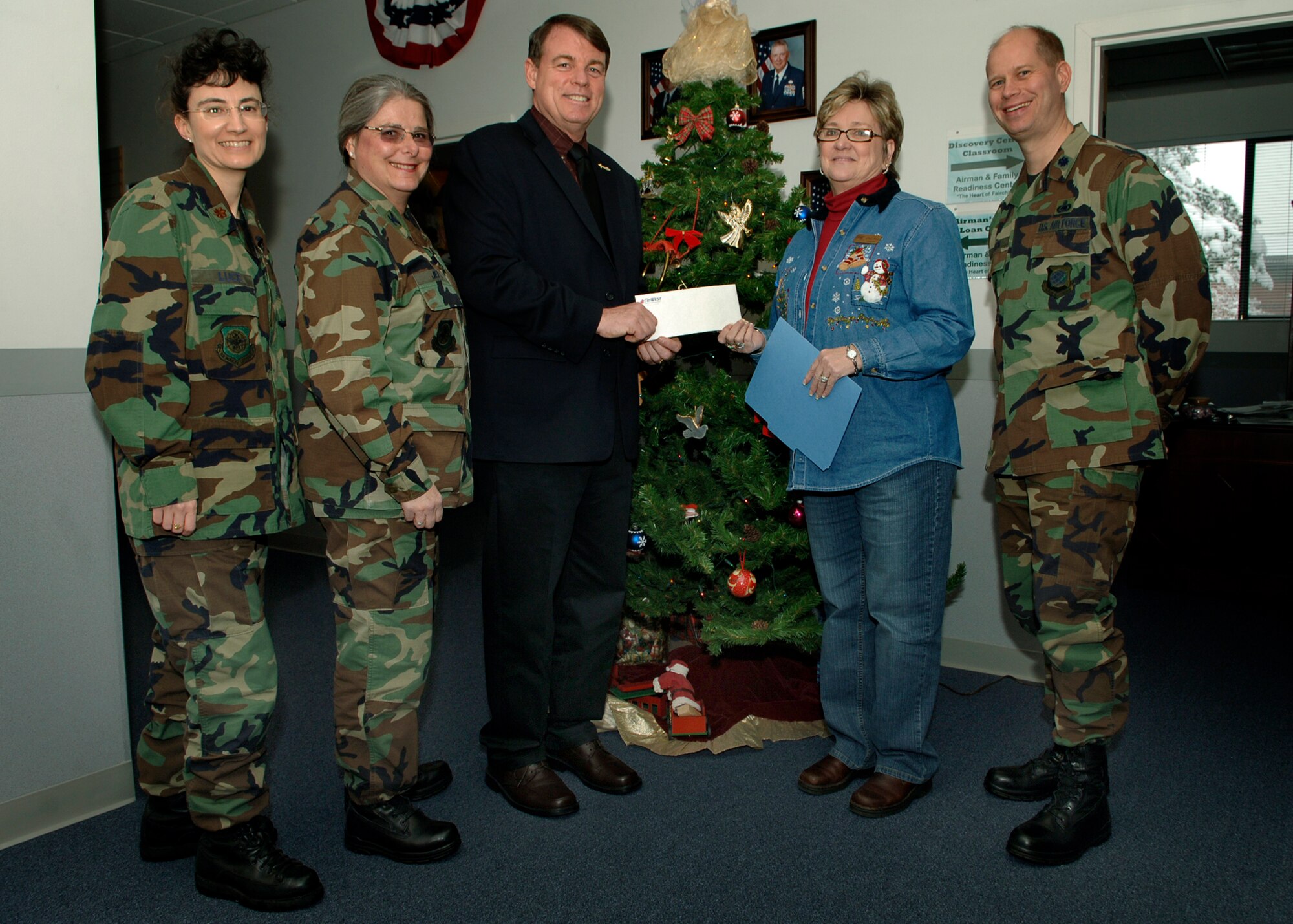 FAIRCHILD AIR FORCE BASE, Wash. --Mike Hanley, TriWest Healthcare Aliiance service area director, presents a $3,000 check to Linda Myles, Airman and Family Readiness Center director, Dec. 13 accompanied by Col. Barbara Jefts, 92nd Medical Group commander; Lt. Col. John Foden, 92nd Mission Support Group deputy commander; and Maj. Judy Luce, from the 92nd Medical Support Squadron flight commander of TRICARE operations and patient administration. (U.S. Air Force photo / Airman 1st Class Joshua K. Chapman)