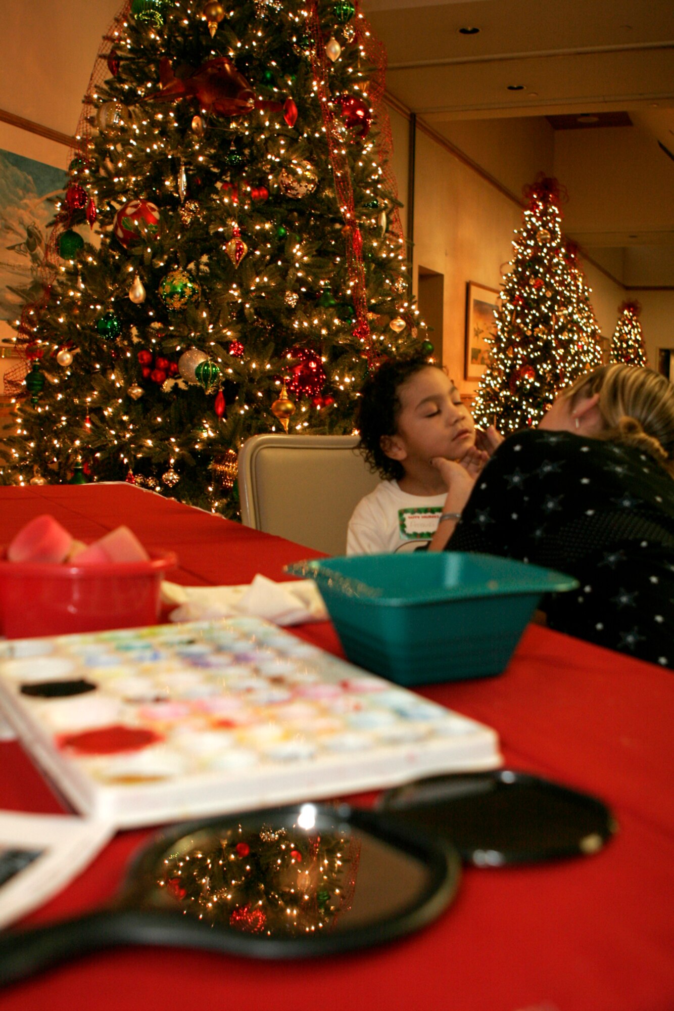 Amauri Connerly, 3, gets his face painted by a volunteer at the 99th Air Base Wing Commander’s Children’s Holiday Party, held at the officer’s club Dec. 15. Nellis and Creech families brought more than 300 children to the event to enjoy activities such as games, raffles, cookie decorating and a visit from Santa Claus. (U.S. Air Force photo by Staff Sgt. Jacob R. McCarthy)