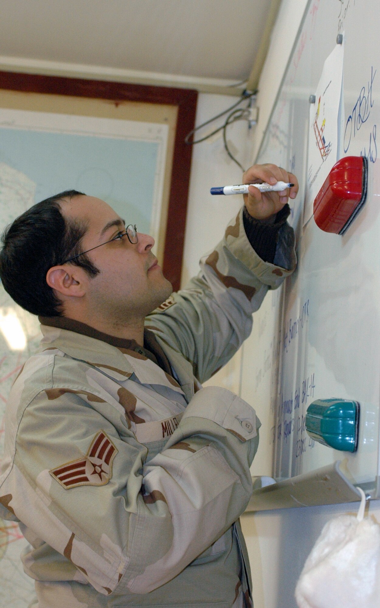 Senior Airman Angel Millet updates the active runway on the airfield status board, which is used to track important airfield information such as the active runway, bird watch condition and barrier status. Airman Millet is an airfield management operations supervisor assigned to the 379th Expeditionary Operations Support Squadron and deployed from Cannon Air Force Base, N.M. (U.S. Air Force photo/Staff Sgt. Jason Barebo)