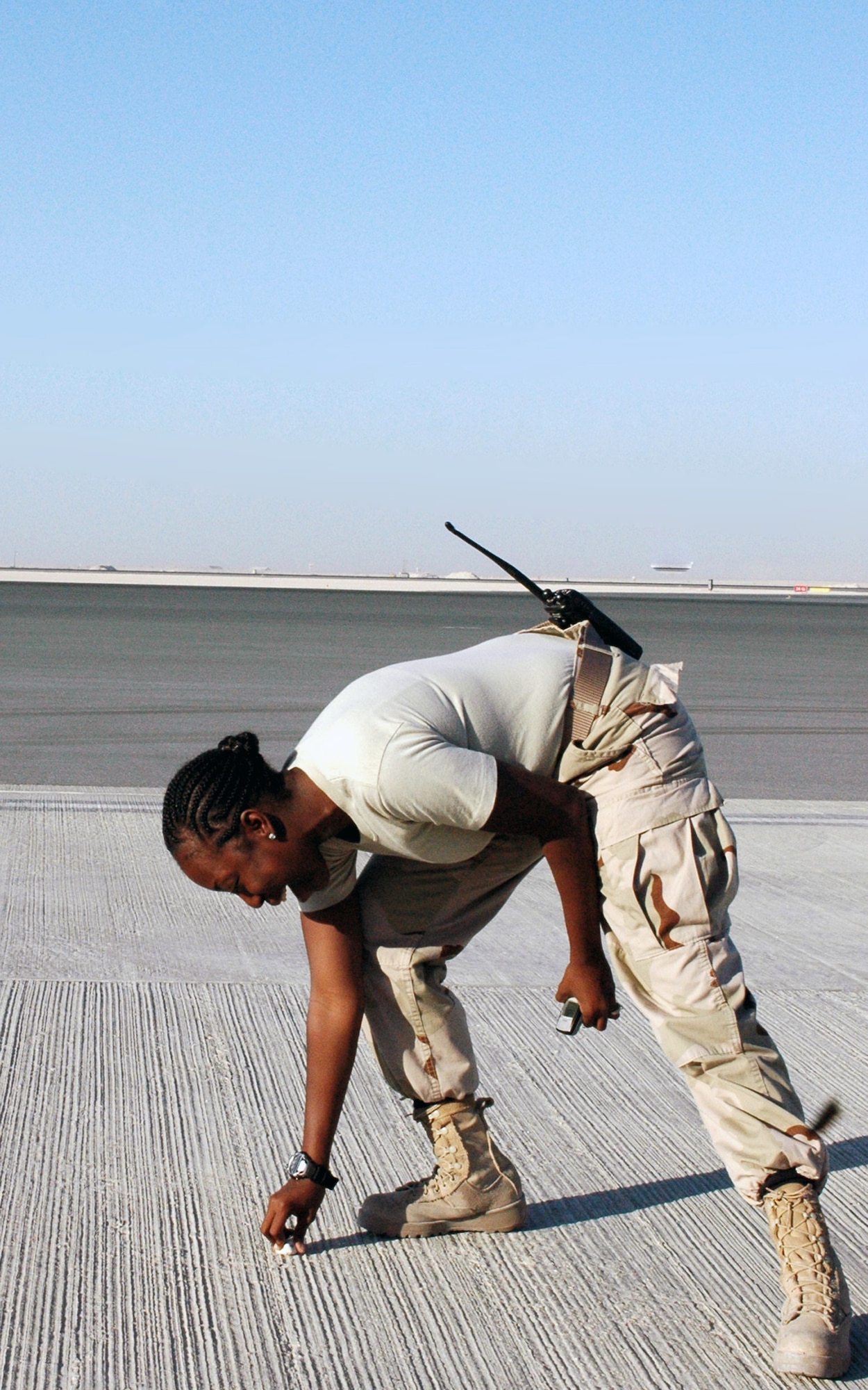 Senior Airman RayShauna Grooms removes foreign object debris from the airfield. Removing FOD from the airfield can prevent serious damage to aircraft engines. Airman Grooms is an airfield management operations supervisor assigned to the 379th Expeditionary Operations Support Squadron and deployed from Holloman Air Force Base, N.M. (U.S. Air Force photo/Staff Sgt. Jason Barebo)
