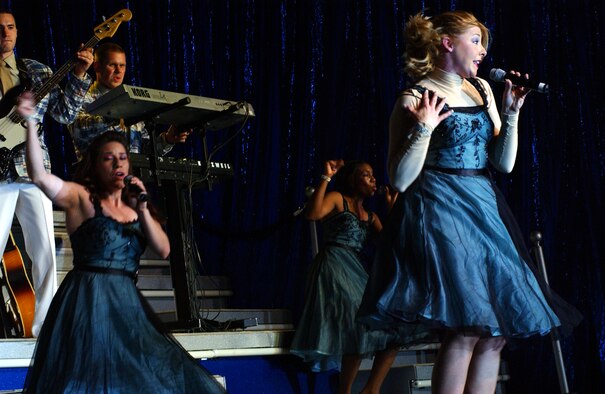 TSgt Jennifer Dack and her group of back up singers perform to the crowd at Hangar 35 during the Tops In Blue show here, Saturday. Photo by Staff Sgt. Erin Smith
