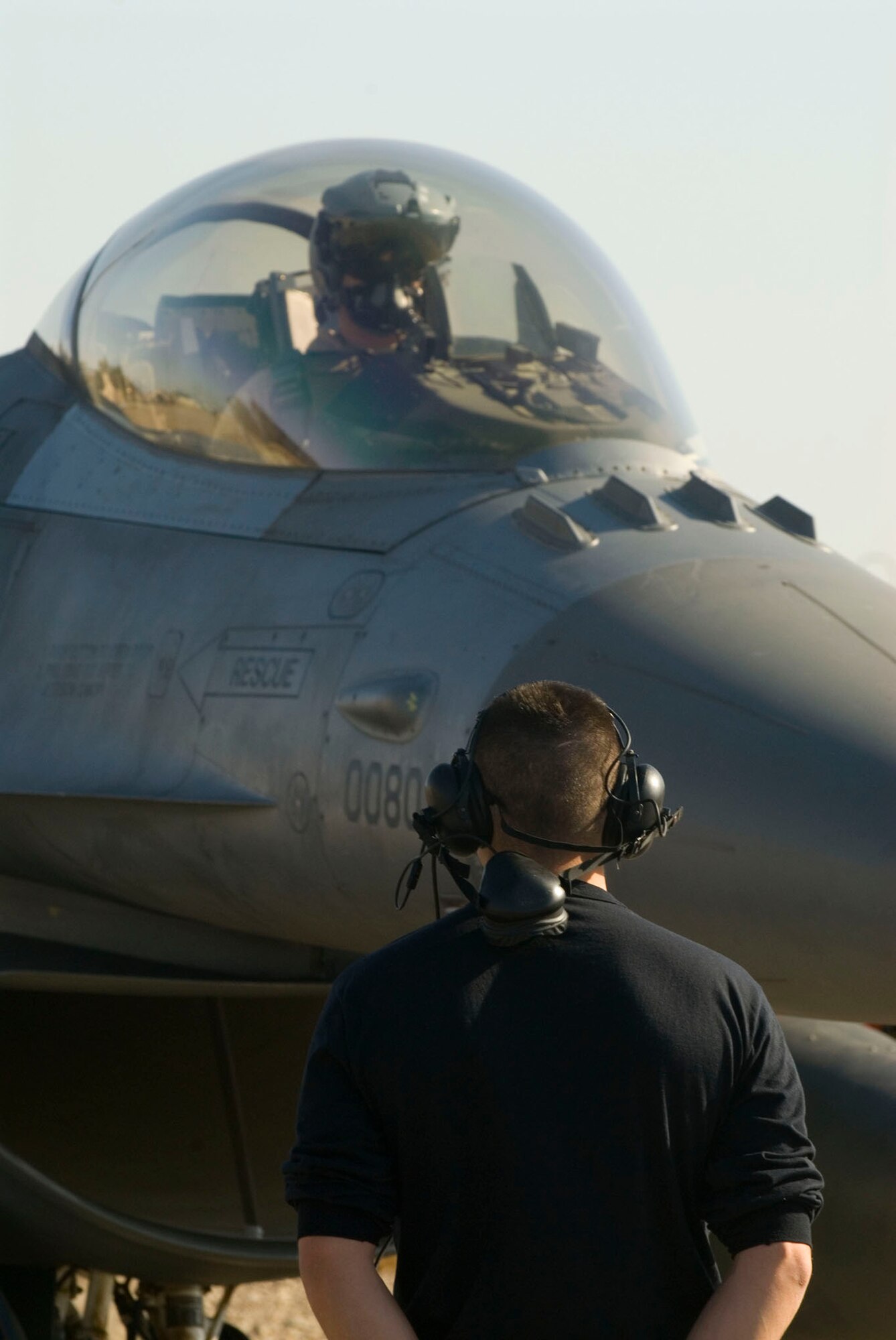 Staff Sgt. William Howe prepares to taxi Capt. Travis Keenan out to the runway Dec. 17 at Balad Air Base, Iraq. After radio communication is disconnected, the pilot and crew chief correspond through hand signals. Sergeant Howe, a 332nd Expeditionary Aircraft Maintenance Squadron crew chief, and Captain Keenan, a 22nd Expeditionary Fighter Squadron pilot, are deployed from Spangdahlem Air Base, Germany. (U.S. Air Force photo/Staff Sgt. Joshua Garcia)
