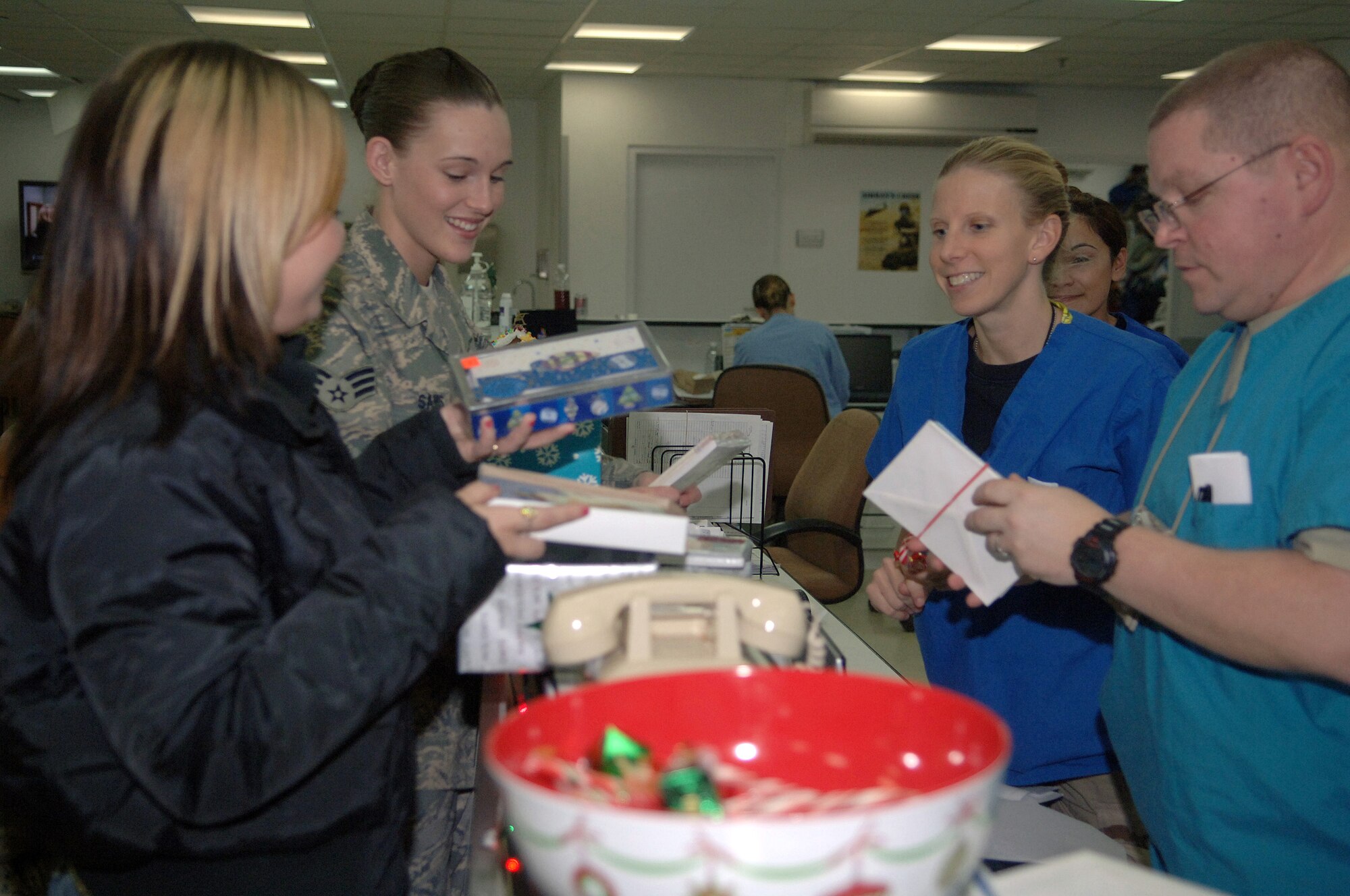 Frances Gonzalez (from left to right) and Senior Airman Amber Sams pass out holiday cards to Capt. Colleen Lamp and Tech. Sgt. John Lafauci Nov. 30 at Balad Air Base, Iraq. Airman Sams is a 332nd Expeditionary Services Squadron recreation coordinator deployed from Langley Air Force Base, Va. Ms. Gonzalez is a Cards for Troops volunteer. Captain Lamp and Sergeant Lafuci are assigned to the 332nd Expeditionary Medical Operations Squadron intermediate care ward and deployed from Lackland AFB, Texas.(U.S. Air Force photo/Senior Airman Terri Barriere) 