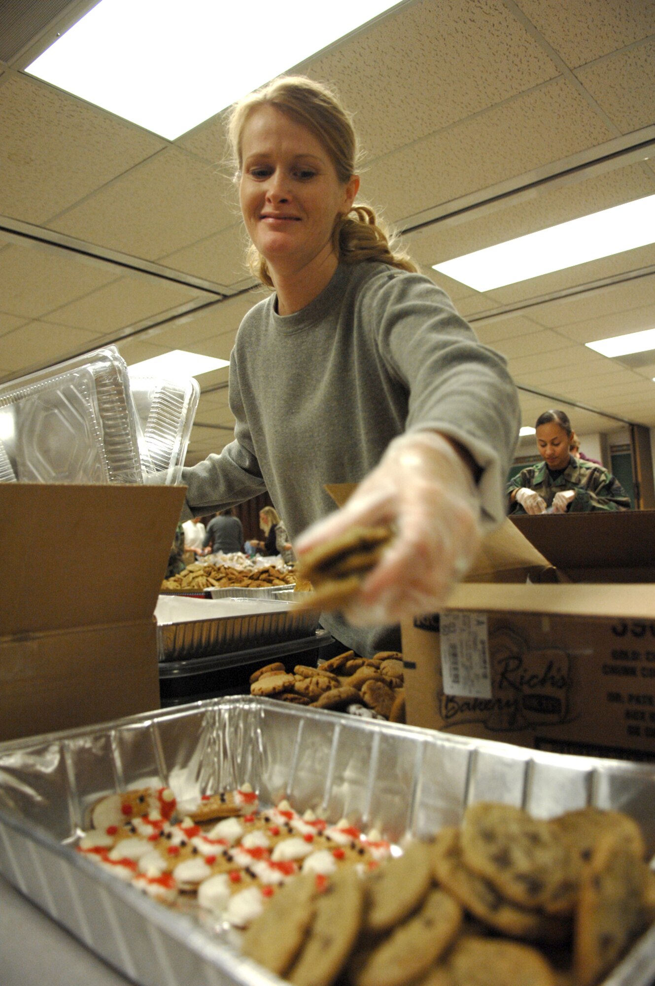 Angela Merchant, replenishes a cookie pan for packaging during the Nellis Airmen's Cookie Drive Dec. 17. The Airmen's cookie drive provides more than 1,000 single Airmen living in the dormitories, cookies for the holidays. (U.S. Air Force photo by Senior Airman Larry E. Reid Jr.)