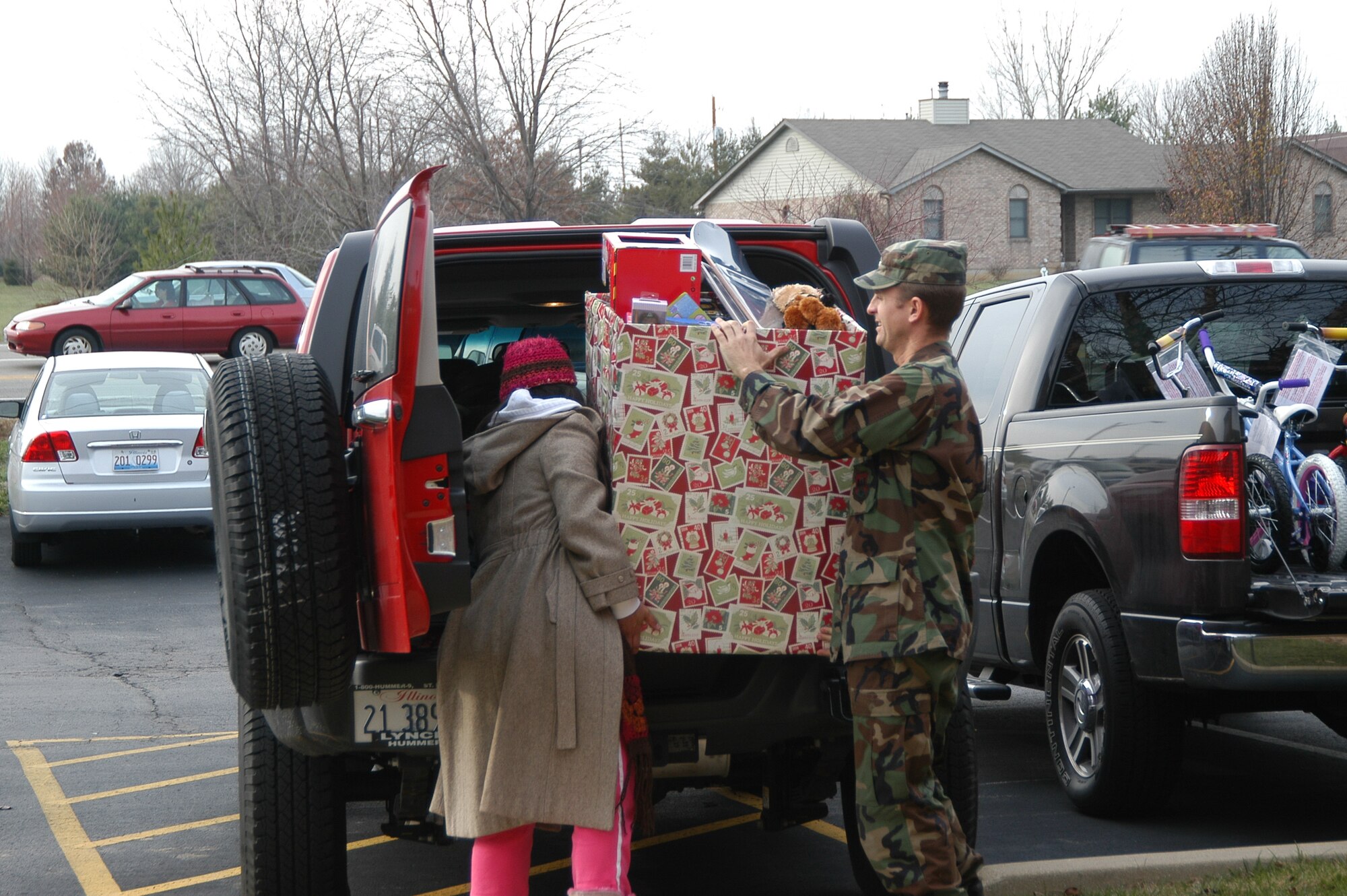 SCOTT AIR FORCE BASE, Ill. -- Scott Company Grade Officers Council president 1st Lt. Mariabethy Cash, member 1st Lt. Charles Lueker and Operation Holiday Cheer project coordinator 1st Lt. Jennifer Preyer load up bikes and toys donated by Thouvenot, Wade and Moerchen, a local business owned by Mr. Rollie Thouvenot.  The donation was one of several made to Operation Holiday Cheer this year, a program that ensures all Joint Total Force Scott families are able to enjoy the holidays. (U.S. Air Force photo by Christi Spargur)