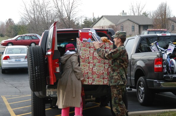 SCOTT AIR FORCE BASE, Ill. -- Scott Company Grade Officers Council president 1st Lt. Mariabethy Cash, member 1st Lt. Charles Lueker and Operation Holiday Cheer project coordinator 1st Lt. Jennifer Preyer load up bikes and toys donated by Thouvenot, Wade and Moerchen, a local business owned by Mr. Rollie Thouvenot.  The donation was one of several made to Operation Holiday Cheer this year, a program that ensures all Joint Total Force Scott families are able to enjoy the holidays. (U.S. Air Force photo by Christi Spargur)