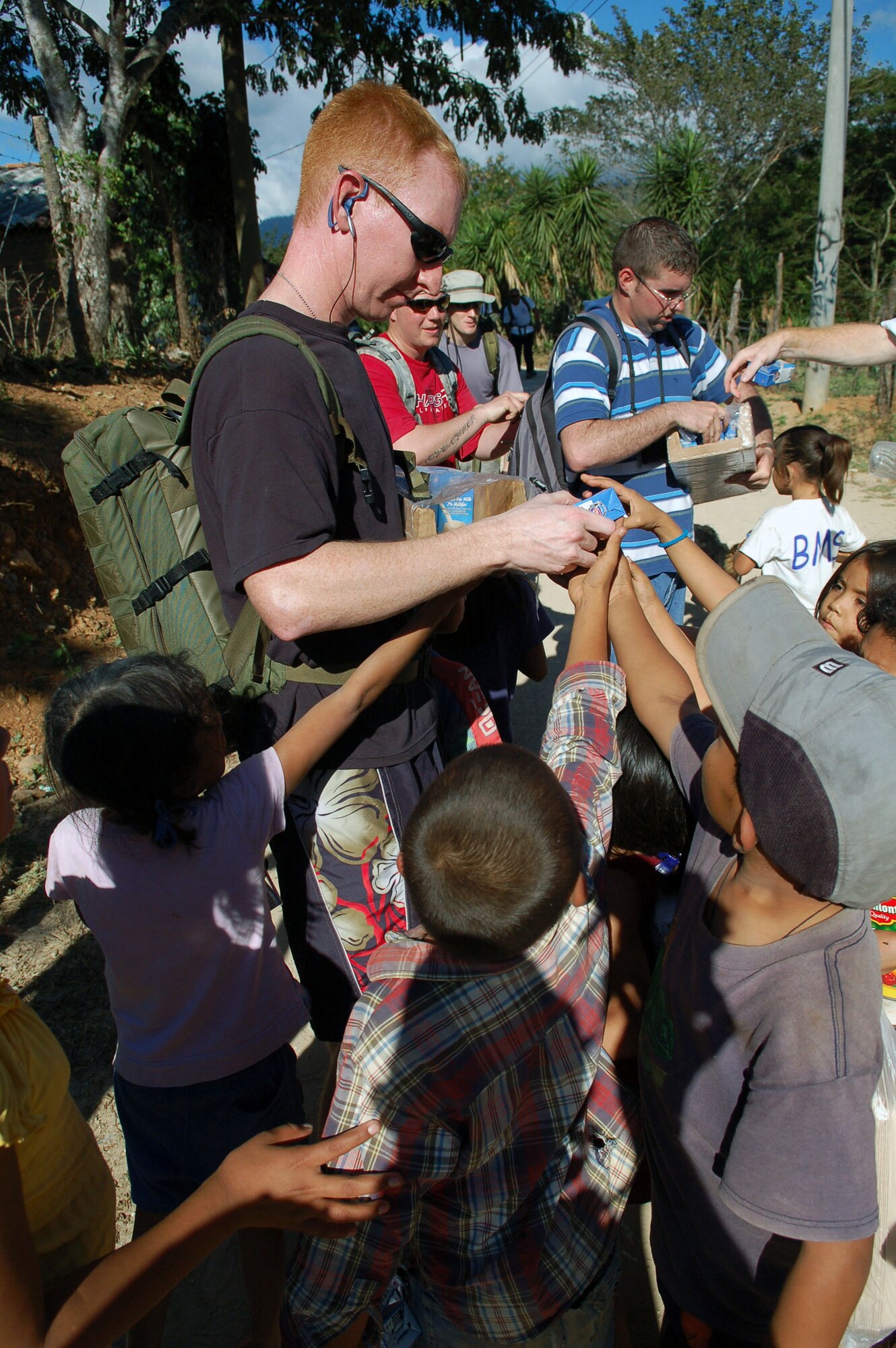 Staff Sgt. Charles Alford hands milk to a crowd of children Dec. 14 in the village of Capiro, Honduras. The sergeant was one of about 60 servicemembers who attended a three-mile hike, sponsored by the JTF-Bravo chapel, to the village to deliver 600 pounds of food. (U.S. Air Force photo/Staff Sgt. Austin M. May) 

