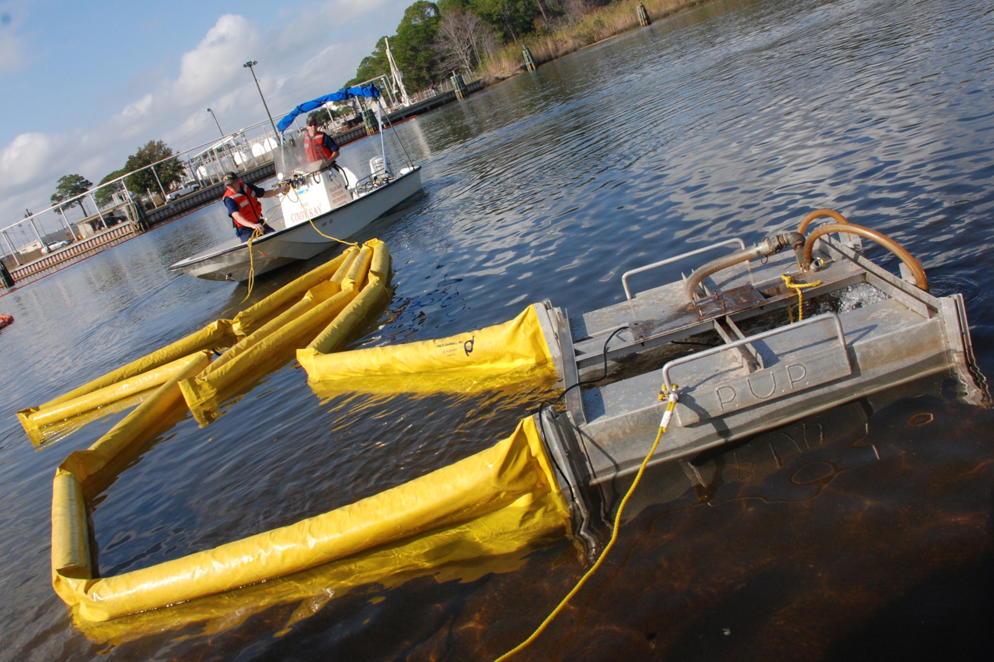 EGLIN AIR FORCE BASE, Fla. -- Airmen and Coast Guardsmen learned to use a Pollution Unit Pump, or PUP, a device used to push product spilled into a holding area to be collected during a fuel spill exercise Dec. 14 in Weekly Bayou. The Air Force and Coast Guard deployed more than 6,500 feet of boom during a week-long training exercise familiarizing them with the processes and equipment needed to clean up fuel spilled into the waters bordering Eglin's southern edge. Eglin has a water front bulk fuel storage facility that receives a barge of more than one million gallons of jet fuel every eight to 10 days. (U.S. Air Force photo by Staff Sgt. Mike Meares)