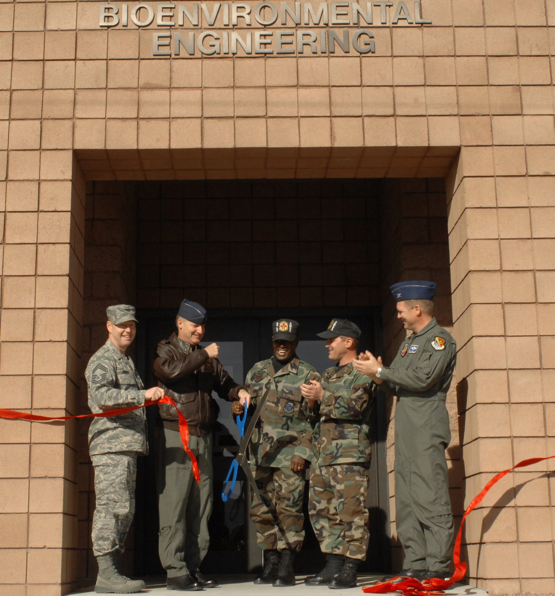 (From left to right) Chief Master Sgt. John Murray, 99th Medical Group superintendent, Col. Michael Bartley, 99th Air Base Wing commander, Senior Master Sgt. Bobby McGregor, Bioenvironmental Engineering Flight superintendent, Maj. Craig Refosco, Bioenvironmental Engineering Flight commander, and Col. Christian Benjamin, 99th Medical Group commander, officially open the new bioenvironmental building during a ribbon cutting ceremony here, Dec. 12. The BEE Flight provides preventative medicine services to the Nellis population through proactive procedures designed to reduce or eliminate exposure to a variety of hazards. (U.S. Air Force photo by Staff Sgt. Taylor Worley)