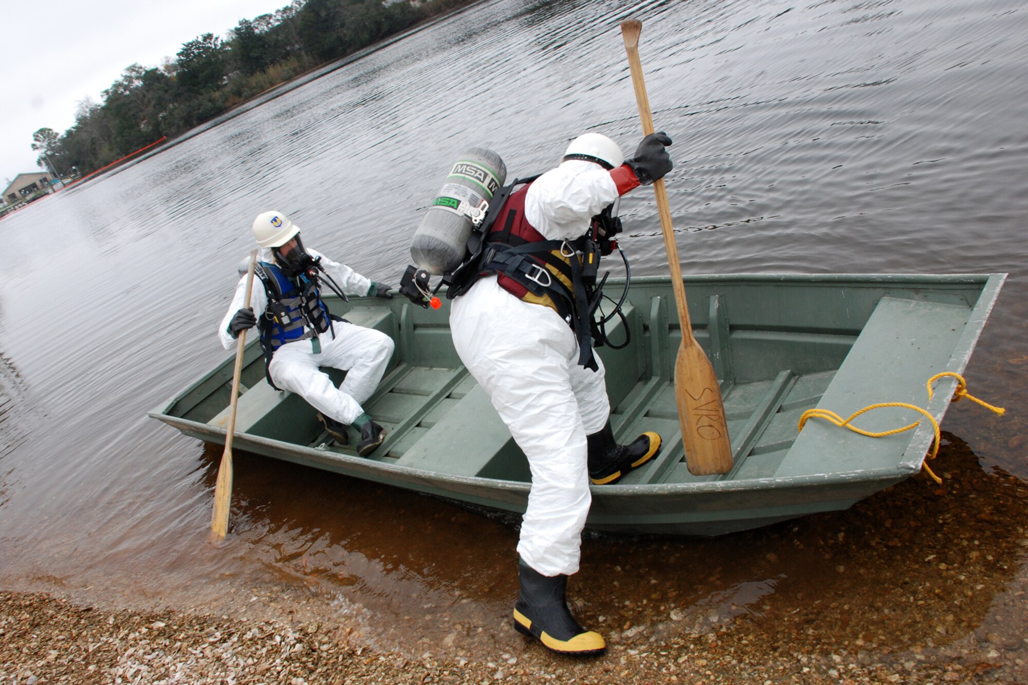 EGLIN AIR FORCE BASE, Fla. -- U.S. Coast Guard Marine Science Technician 1st Class Jay Matullonis and MST3 Joe O'Brien climb into a row boat to enter the waters of Weekly Bayou to take readings of the fuel spill during the exercise Dec. 14.
The Air Force and Coast Guard deployed more than 6,500 feet of boom during a week-long training exercise familiarizing them with the processes and equipment needed to clean up fuel spilled into the waters bordering Eglin?s southern edge. Eglin has a water front bulk fuel storage facility that receives a barge of more than one million gallons of jet fuel every eight to 10 days. (U.S. Air Force photo by Staff Sgt. Mike Meares)
