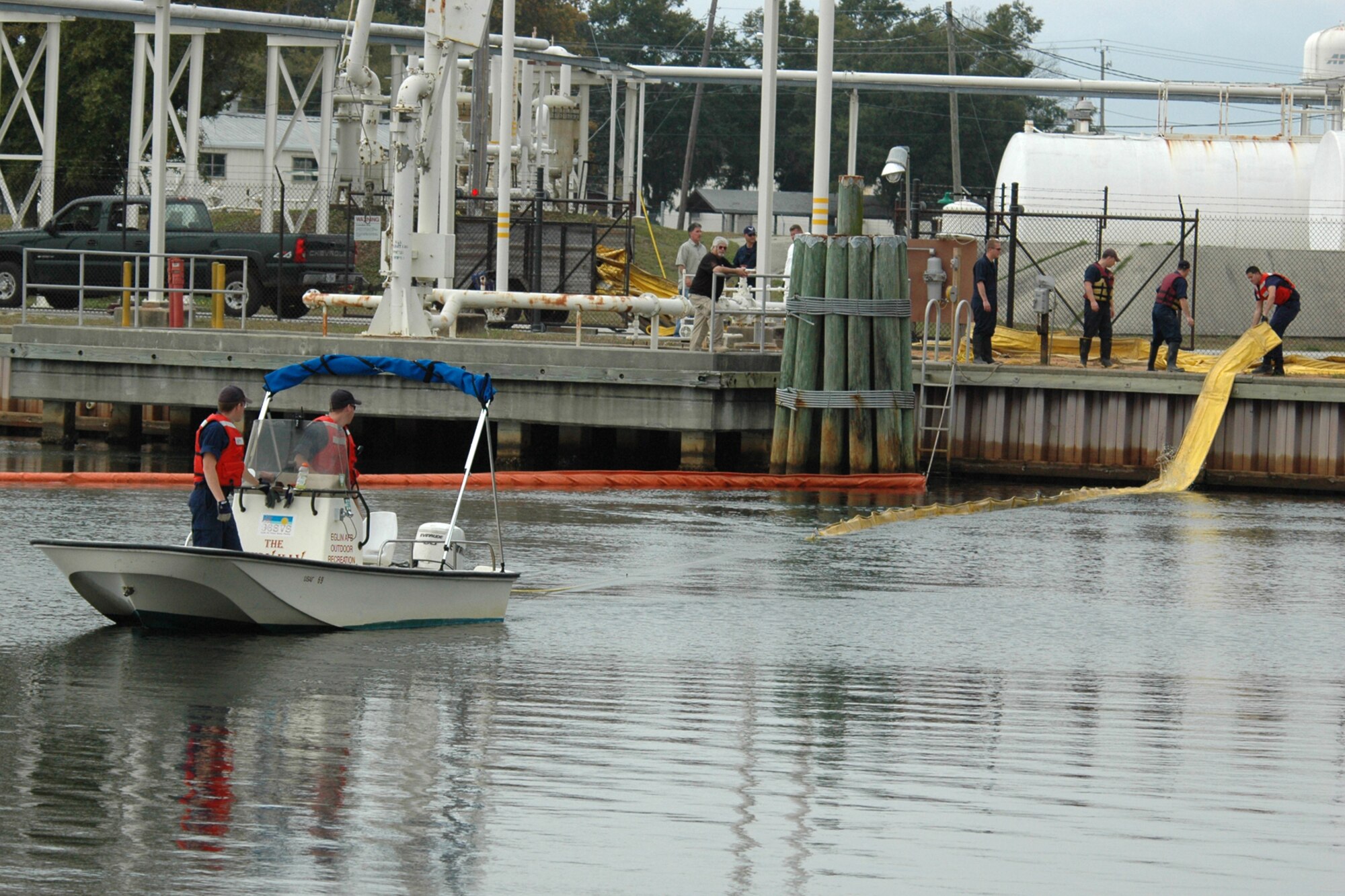 EGLIN AIR FORCE BASE, Fla. -- Boom is deployed into Weekly Bayou Dec. 14 during a fuel spill exercise at the bulk fuel storage tanks on Eglin. The Air Force and Coast Guard deployed more than 6,500 feet of boom during a week-long training exercise familiarizing them with the processes and equipment needed to clean up fuel spilled into the waters bordering Eglin?s southern edge. Eglin has a water front bulk fuel storage facility that receives a barge of more than one million gallons of jet fuel every eight to 10 days. (U.S. Air Force photo by Staff Sgt. Mike Meares)
