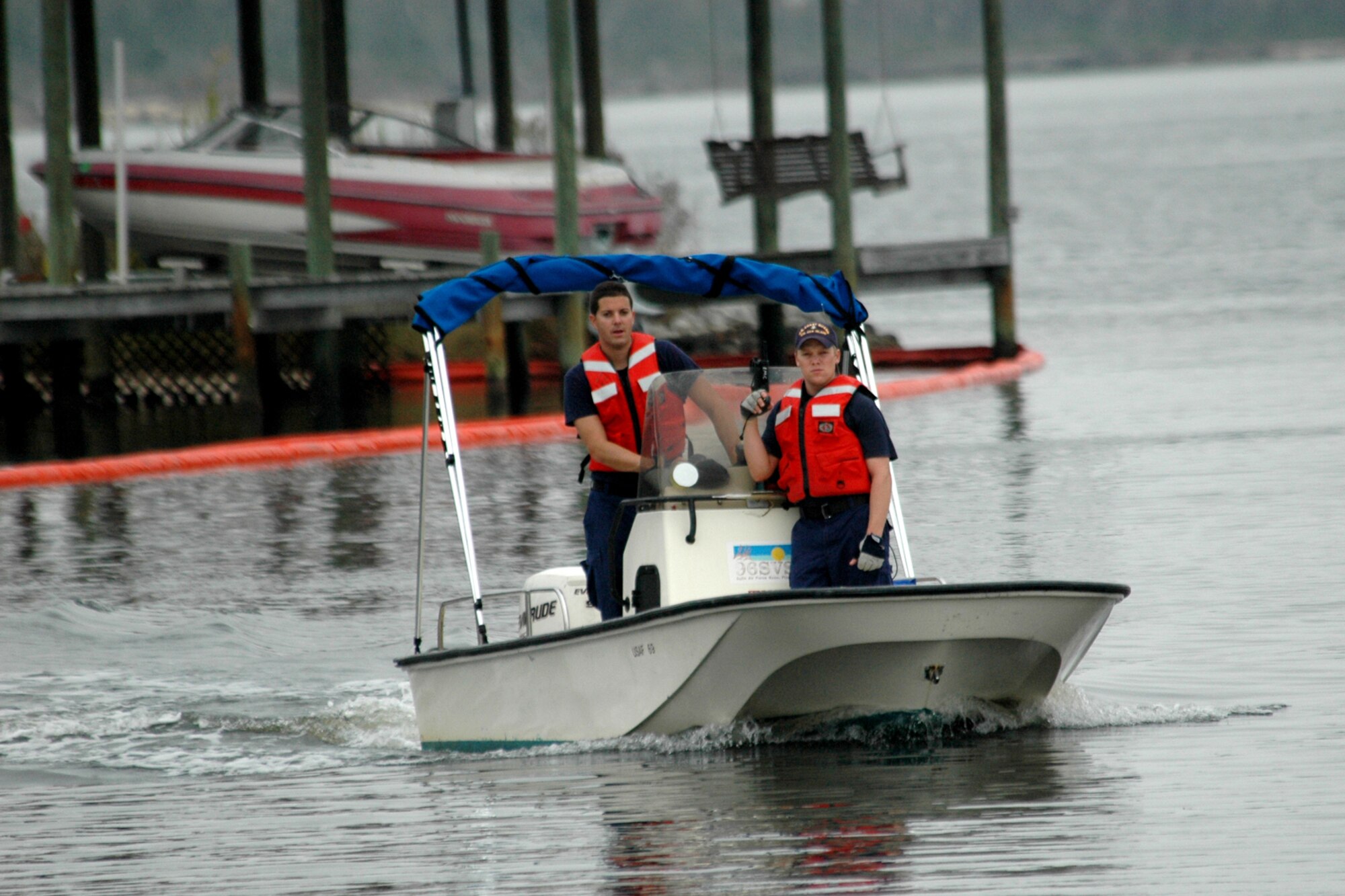 EGLIN AIR FORCE BASE, Fla. -- U.S. Coast Guard Boatswain Mate 2nd Class Travis Capps and BO3 Brennan Reeves return to shore after securinga  section of boom Dec. 14 during a fuel spill exercise in Weekly Bayou. The Air Force and Coast Guard deployed more than 6,500 feet of boom during a week-long training exercise familiarizing them with the processes and equipment needed to clean up fuel spilled into the waters bordering Eglin?s southern edge. Eglin has a water front bulk fuel storage facility that receives a barge of more than one million gallons of jet fuel every eight to 10 days. Petty Officer Capps is from Station Hatteras Inlet, N.C., and  Petty Officer Reeves is at Station Oak Island, N.C. (U.S. Air Force photo by Staff Sgt. Mike Meares)