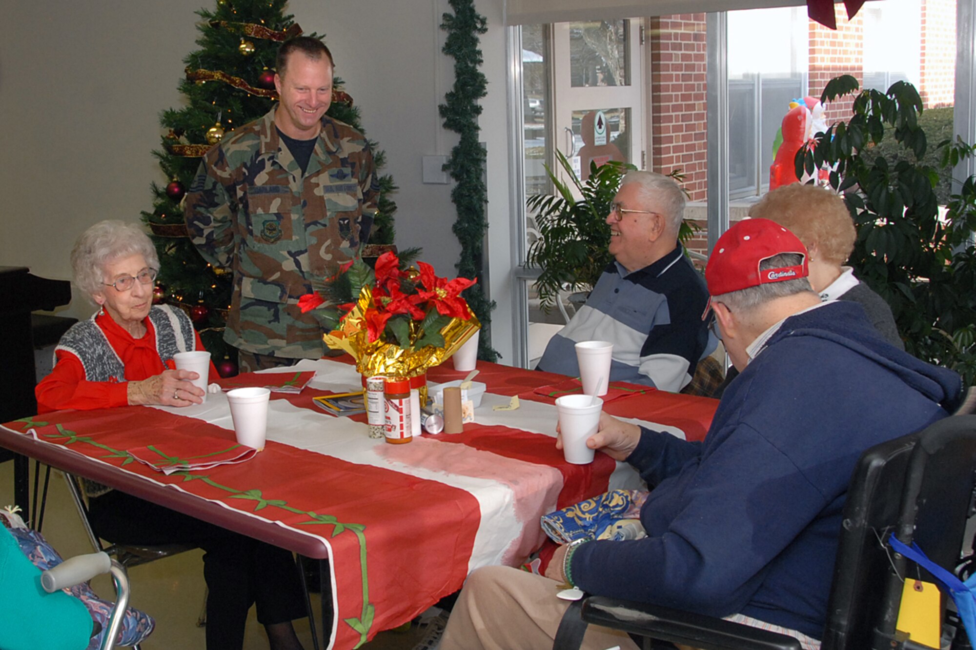 SCOTT AIR FORCE BASE, Ill. -- Master Sgt. Todd Garland, Air Mobility Command volunteer, visits with retired vets as he serves holiday dinner to the Veterans during the annual "Christmas with the Vets" visit at the Quincy Illinois Veteran's Retirement Home. (U.S. Air Force photo by Marv Lynchard)