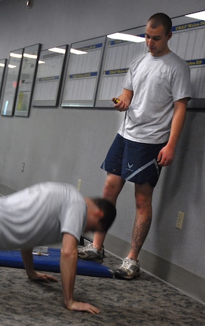 Airman 1st Class Robert Kayser, 437th Maintenance Squadron, times Senior Airman Jonathan Mansel, 437 MXS, during his push-up session at the Fitness and Sports Center Dec. 14. (U.S. Air Force photo/Airman 1st Class Melissa White)