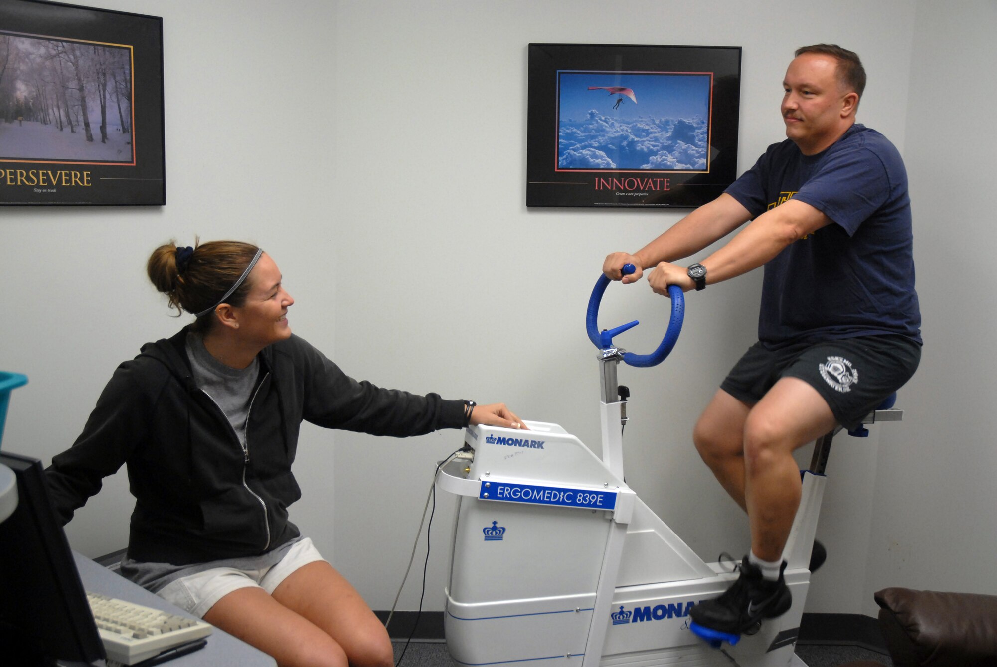 Linda Markuly, 437th Medical Group Health and Wellness Center exercise physiologist, and Master Sgt. Scot Borgerding, 437th Communications Squadron, demonstrate the ergo bike test for the Physical Training Leader Class at the HAWC Dec. 14. (U.S. Air Force photo/Airman 1st Class White)