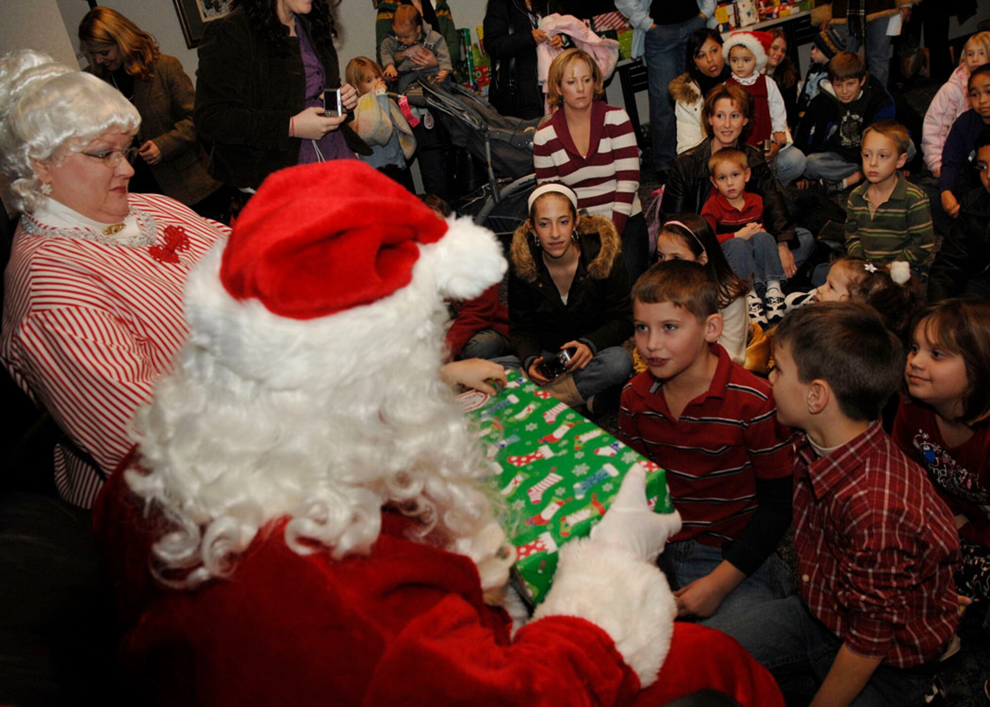 SCOTT AIR FORCE BASE, Ill. -- Santa and Mrs. Claus give presents to children at the Airman and Family Readiness Center Dec. 14 during the Hearts Apart Holiday Event. (U.S. Air Force photo by Airman 1st Class Megan Gilliand)