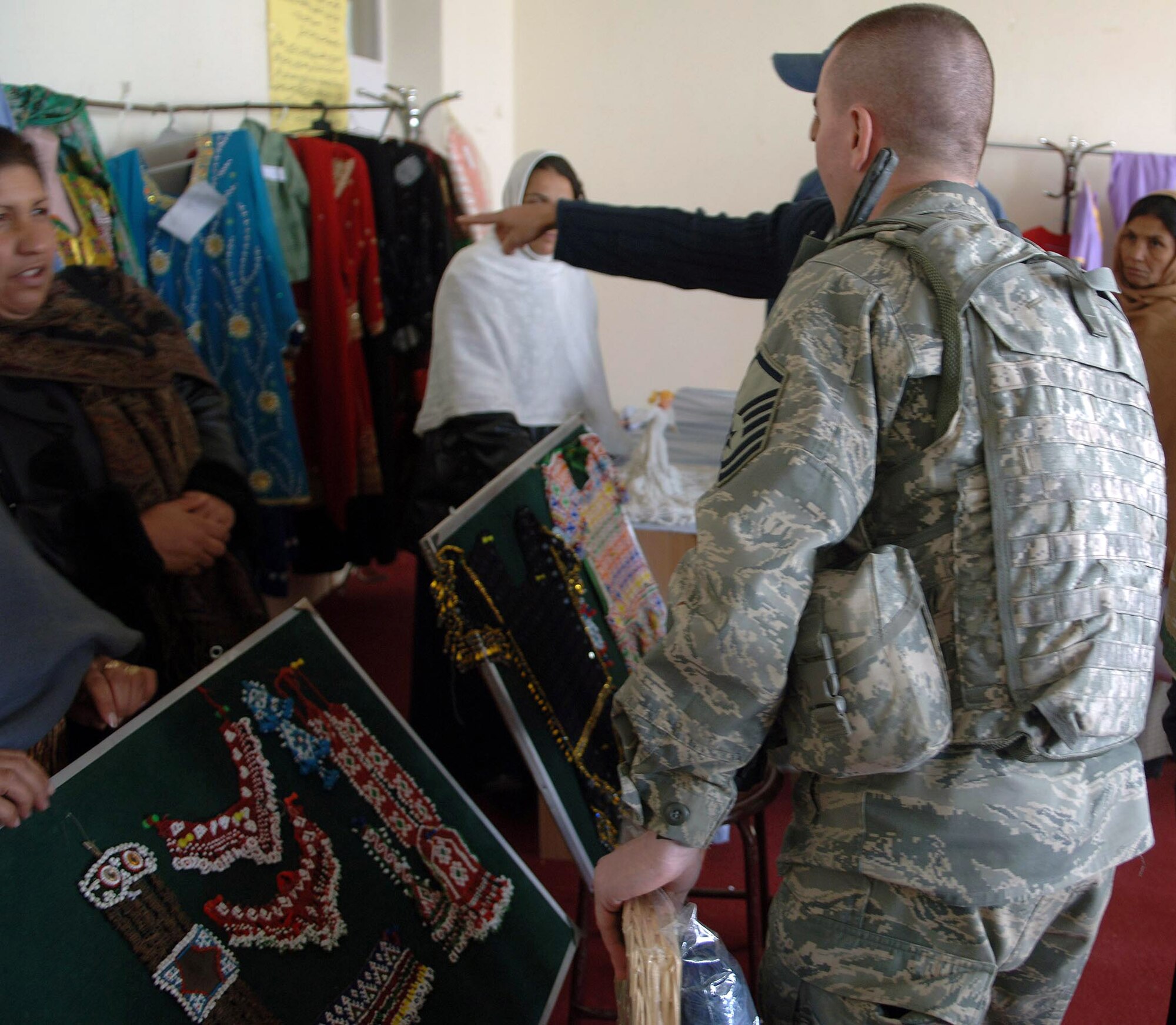 KAPISA PROVINCE, Afghanistan - Master Sgt. Charles Liston examines the handmade crafts during the opening of a women's shelter Dec. 13 in Kapisa Province, Afghanistan. The Bagram Provincial Reconstruction Team provided more than $86,000 in support of the shelter's construction, which was accomplished by local contractors. Sergeant Liston is the Structural Superintendent for the Bagram Provincial Reconstruction Team. (U.S. Air Force photo/Staff Sgt. Mike Andriacco)