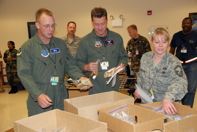 CURACAO, The Netherlands Antilles -- From left, Air Force Staff Sgt. Reid Beveridge, Capt. Andy Maus, and Senior Master Sgt. Kelly Cahalan, all deployed from the 55th Wing at Offutt Air Force Base, Neb., enjoy donated cookies from Davis-Monthan Air Force Base, Ariz.   The "Cookie Caper" morale mission allowed 12th Air Force leaders to visit with deployed servicemembers prior to the holidays. The team delivered more than 9,000 cookies to Honduras, the Netherlands Antilles, Puerto Rico, and Guantanamo Bay Naval Station, Cuba. (U.S. Air Force photo by Tech. Sgt. Sonny Cohrs)

