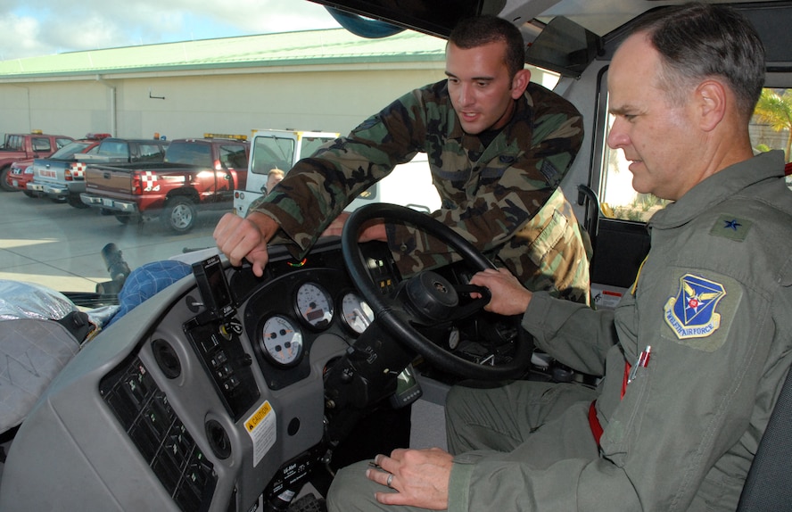 CURACAO, The Netherlands Antilles -- Air Force Senior Airman Jeff Trueman, a firefighter deployed to Curacao, the Netherlands Antilles, explains fire truck operating procedures to Air Force Brig. Gen. Joseph Mudd, 12th Air Force vice commander, Dec. 12.   The general came with the "Cookie Caper" morale mission, which allowed 12th Air Force leaders to visit with deployed servicemembers prior to the holidays. The team delivered more than 9,000 cookies to Honduras, the Netherlands Antilles, Puerto Rico, and Guantanamo Bay Naval Station, Cuba. (U.S. Air Force photo by Tech. Sgt. Sonny Cohrs)