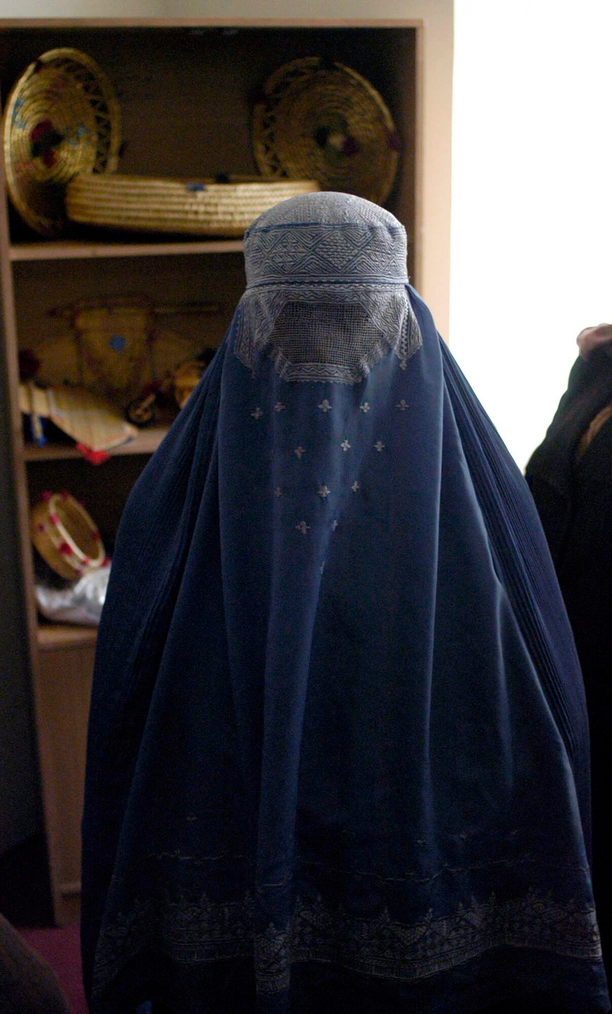 KAPISA PROVINCE, Afghanistan - An Afghan women sells handmade crafts during the opening of a women's shelter Dec. 13 in Kapisa Province, Afghanistan. The Bagram Provincial Reconstruction Team provided more than $86,000 in support of the shelter's construction, which was accomplished by local contractors. (U.S. Air Force photo/Staff Sgt. Mike Andriacco)
