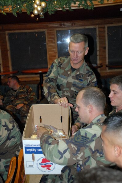 SOTO CANO AIR BASE, Honduras -- Air Force Chief Master Sgt. Wade Johnson, Command Chief for 12th Air Force, delivers cookies to servicemembers from Joint Task Force-Bravo at Soto Cano Air Base, Honduras, Dec. 11. Chief Johnson came with the 'Cookie Caper' morale mission, which allowed 12th Air Force leaders to visit with deployed servicemembers prior to the holidays. The team delivered more than 9,000 cookies to Honduras, the Netherlands Antilles, Puerto Rico, and Guantanamo Bay Naval Station, Cuba. (U.S. Air Force photo by Tech. Sgt. Sonny Cohrs) 

