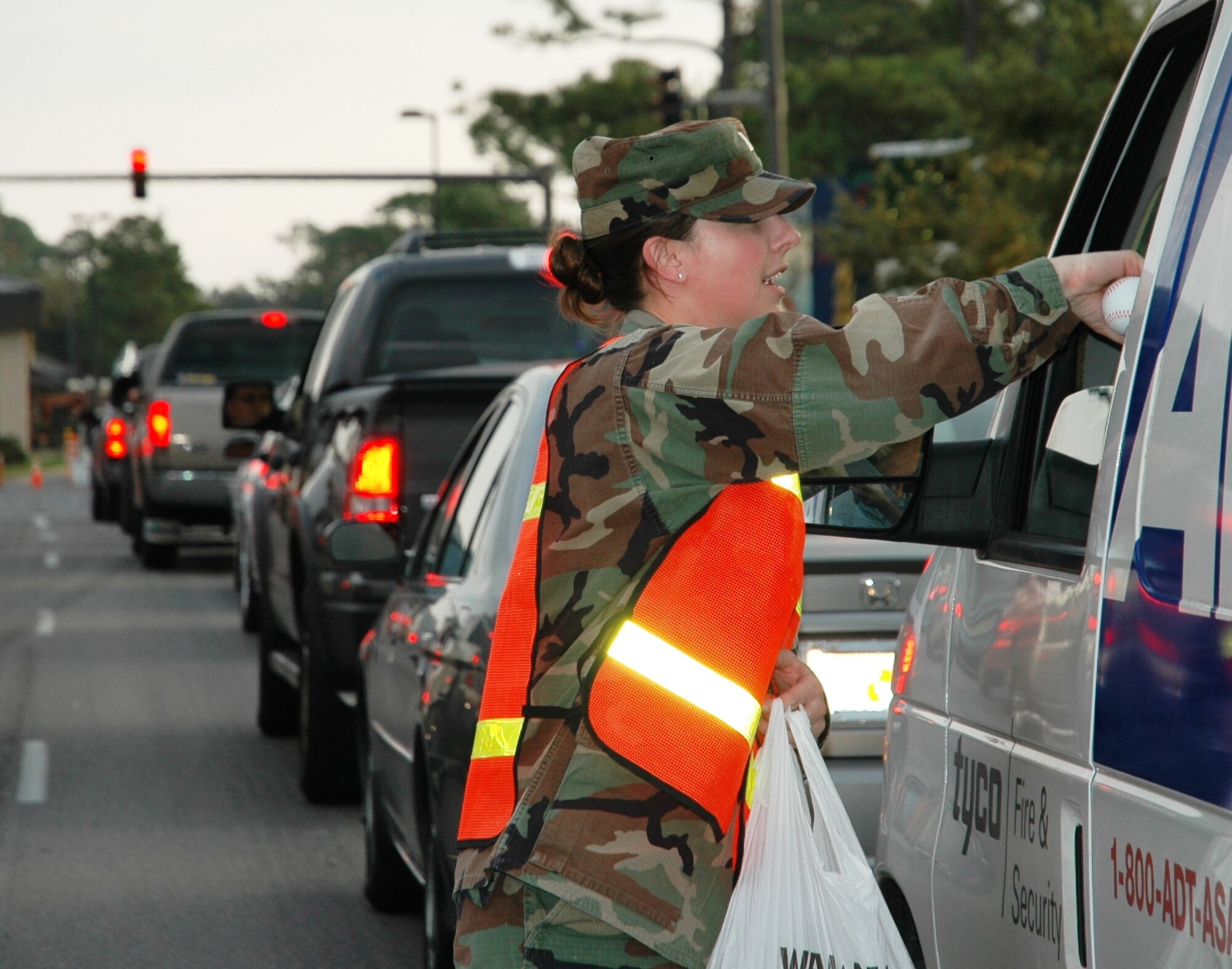1st Lt. Anne Koenig, 11th Intelligence Squadron, gives a stress ball to a driver leaving base Dec. 14. Members of the Company Grade Officer’s Council handed out 1,200 balls at the Hurlburt Field main gate in support of the holiday DUI-prevention campaign. Each ball lists the Airmen Against Drunk Driving phone number. (U.S. Air Force photo/2nd Lt. Lauren Johnson)