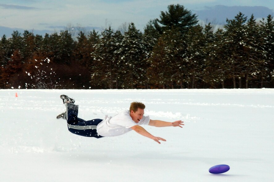 HANSCOM AFB, Mass. -- Joe Zurkus, MIT Lincoln Lab, takes a dive for a frisbee during a game in the snow Dec. 14. (U.S. Air Force Photo by Jan Abate.)