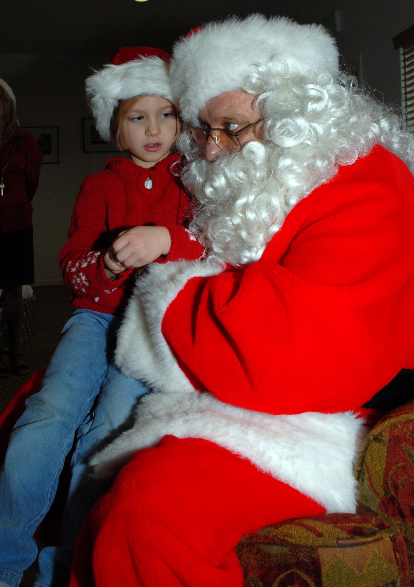 Delaney Mann, shares her Christmas wish with St. Nick at the Breakfast with Santa held at the Eagle Heights Community Center here Dec. 15. Pinnacle hosted the breakfast and invited all base housing residents and their families to attend. The Pinnacle staff cooked a breakfast of pancakes, eggs and sausage, and served it to guests who had group and individual visits by Santa Claus. (U.S. Air Force hoto/Tech. Sgt. Kevin Wallace)
