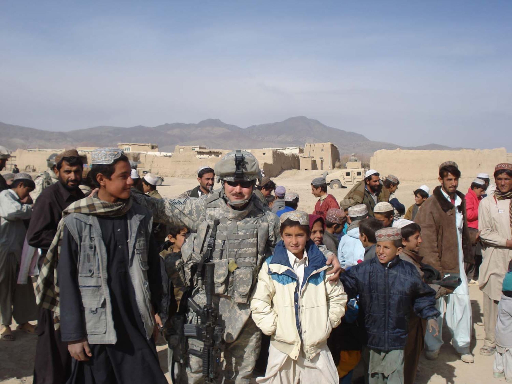 FOB LIGHTNING, Afghanistan -- Master Sgt. James Bardo visits with children from Niazikala during a humanitarian assistance mission. Sergeant Bardo is deployed from the 52nd Equipment Maintenance Squadron at Spangdahlem Air Base, Germany. (Polish Army photo/Warrant Officer Peter Frydrych)