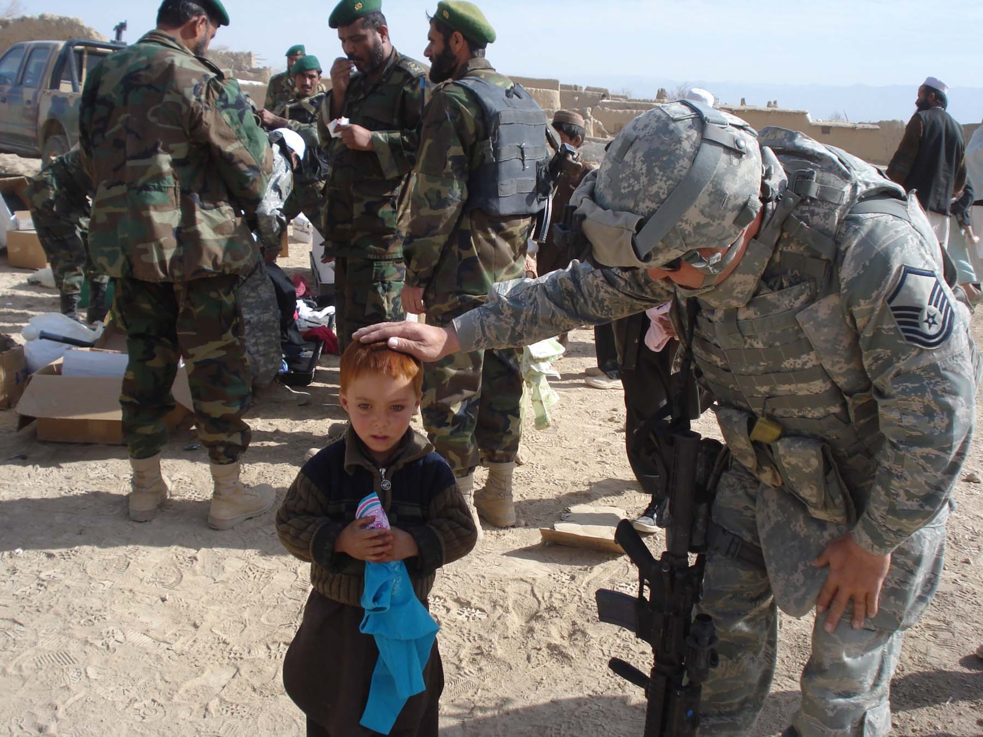 FOB LIGHTNING, Afghanistan -- Master Sgt. James Bardo visits with one of the children from Niazikala. The boy's red hair is colored with Henna. Sergeant Bardo is deployed from the 52nd Equipment Maintenance Squadron at Spangdahlem Air Base, Germany. (U.S. Army photo/2nd Lt. Leslie Madron)
