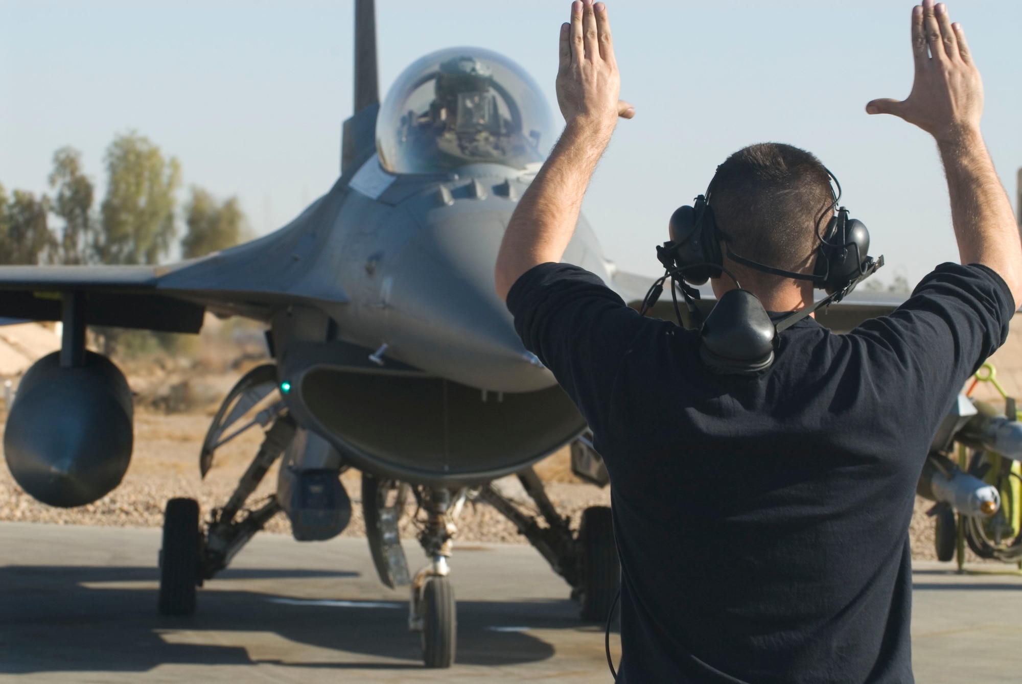 BALAD AIR BASE, Iraq -- Staff Sgt. William Howe, a 332nd Expeditionary Aircraft Maintenance Squadron crew chief, signals Capt. Travis "Bandit" Keenan, a 22nd Expeditionary Fighter Squadron pilot, that it is clear to taxi out to the runway here, Dec. 17. From preflight inspection through the taxing out of the aircraft, pilot and crew chief stay in constant communication via radio headset or hand signals. Captain Keenan and Sergeant Howe are deployed from Spangdahlem Air Base, Germany. (U.S. Air Force photo/Staff Sgt. Joshua Garcia)