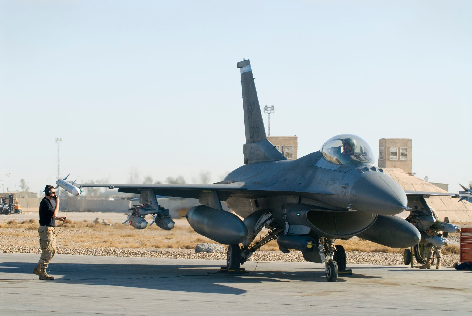 BALAD AIR BASE, Iraq -- Staff Sgt. William Howe, a 332nd Expeditionary Aircraft Maintenance crew chief, talks with Capt. Travis "Bandit" Keenan, a 22nd Expeditionary Fighter Squadron pilot, via headset during a prior to takeoff. Communication between the pilot and the crew chief ensures that there are no discrepancies with aircraft functions prior to flight. Sergeant Howe and Captain Keenan are deployed from Spangdahlem Air Base, Germany. (U.S. Air Force photo/Staff Sgt. Joshua Garcia)
