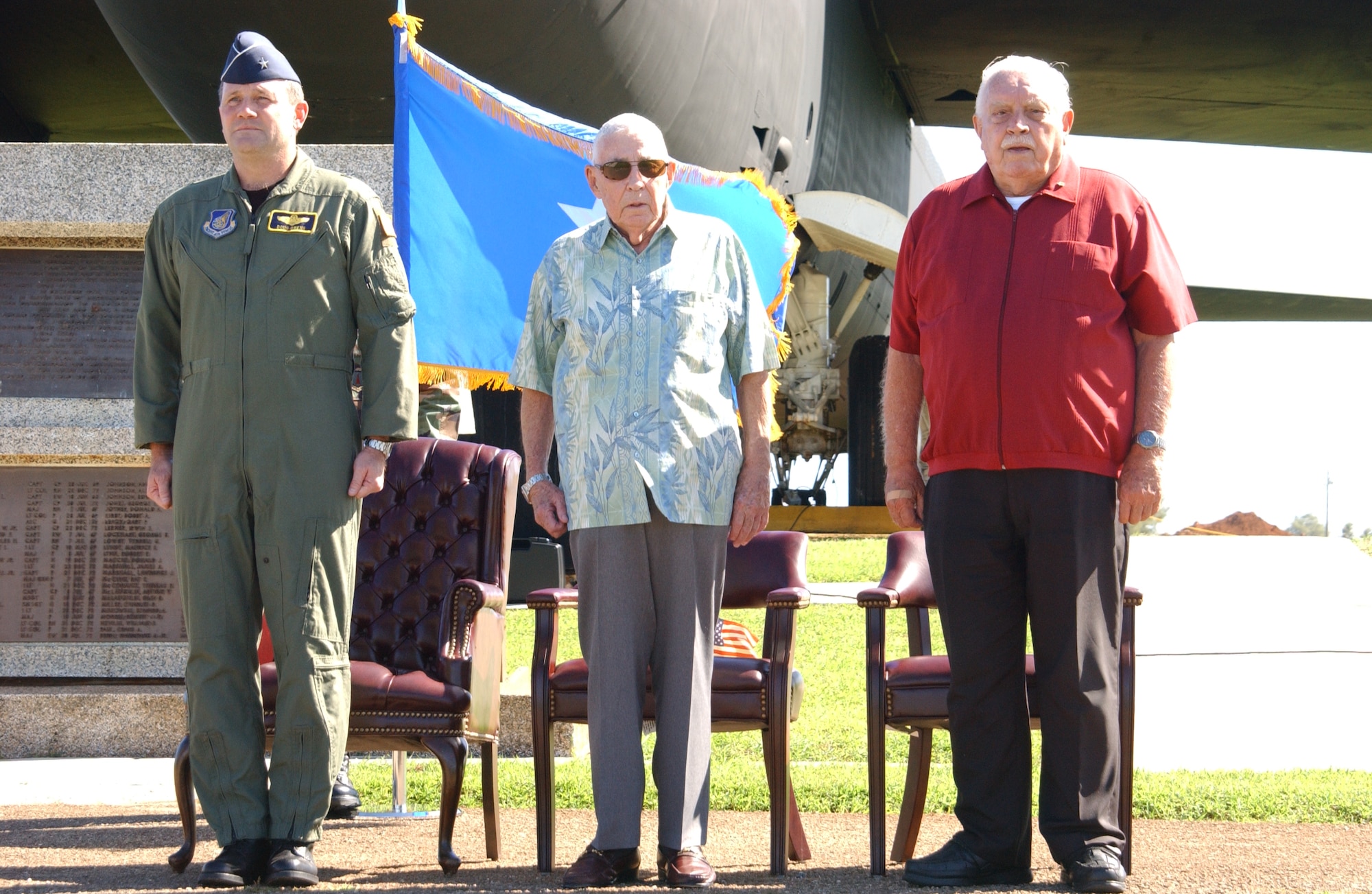 Retired Col. Tony Merritt and retired Lt. Col. Chuck McManus, Airmen who were directly involved with Linebacker II, stand beside Brig. Gen. Douglas Owens, 36th Wing commander, as the Guam hymn is sang before the start of the ceremonies. Mr. Merritt later accompanied General Owens to place a memorial wreath at the base of the flag pole in Arc Light Memorial park to mark the sacrifice made by the heroic Airmen in Linebacker II. (Air Force photo/Tech. Sgt. Steven Wilson)